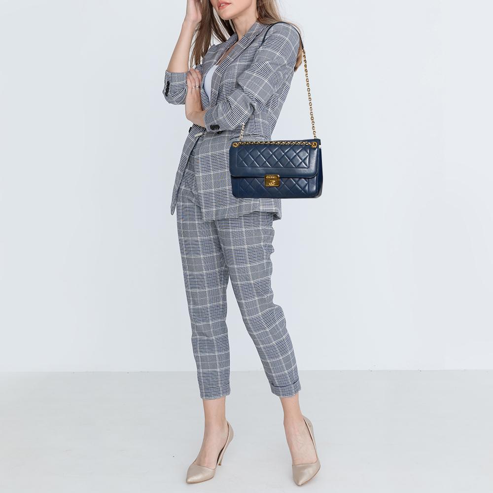 Get this elegant and classy 'Chic With Me' flap bag from Chanel! Made in soft leather, the blue beauty features the signature quilting all over the exterior and is accented with a striking gold-tone CC lock closure at the front flap. With an