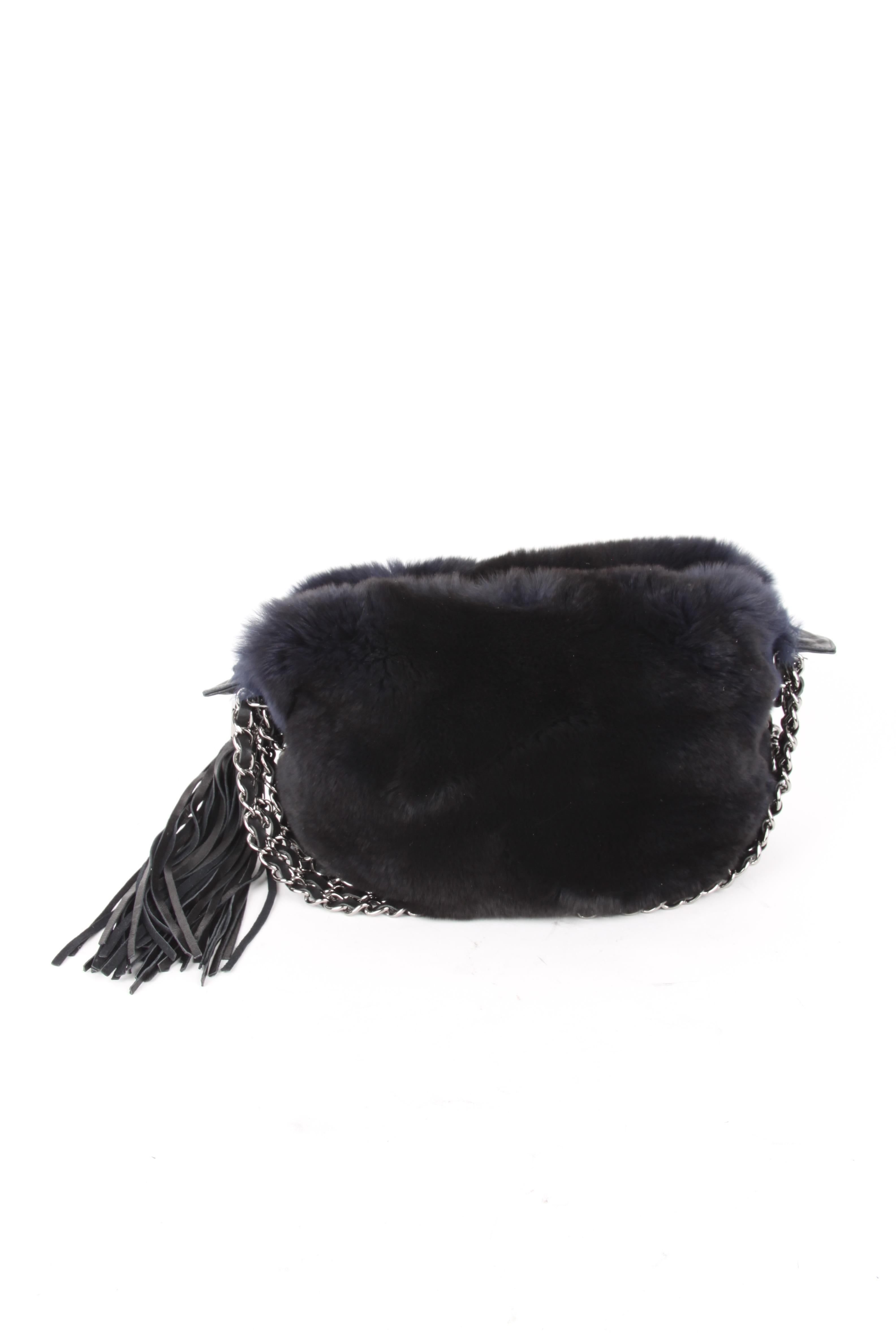 Chanel Blue Rabbit Fur Leather Three Chain Shoulder Handbag.

This little bag makes a big statement. It features a lux blue rabbit fur exterior with a silvertone chain and black entwined leather handles. The bag features a blue silk lining, zipper