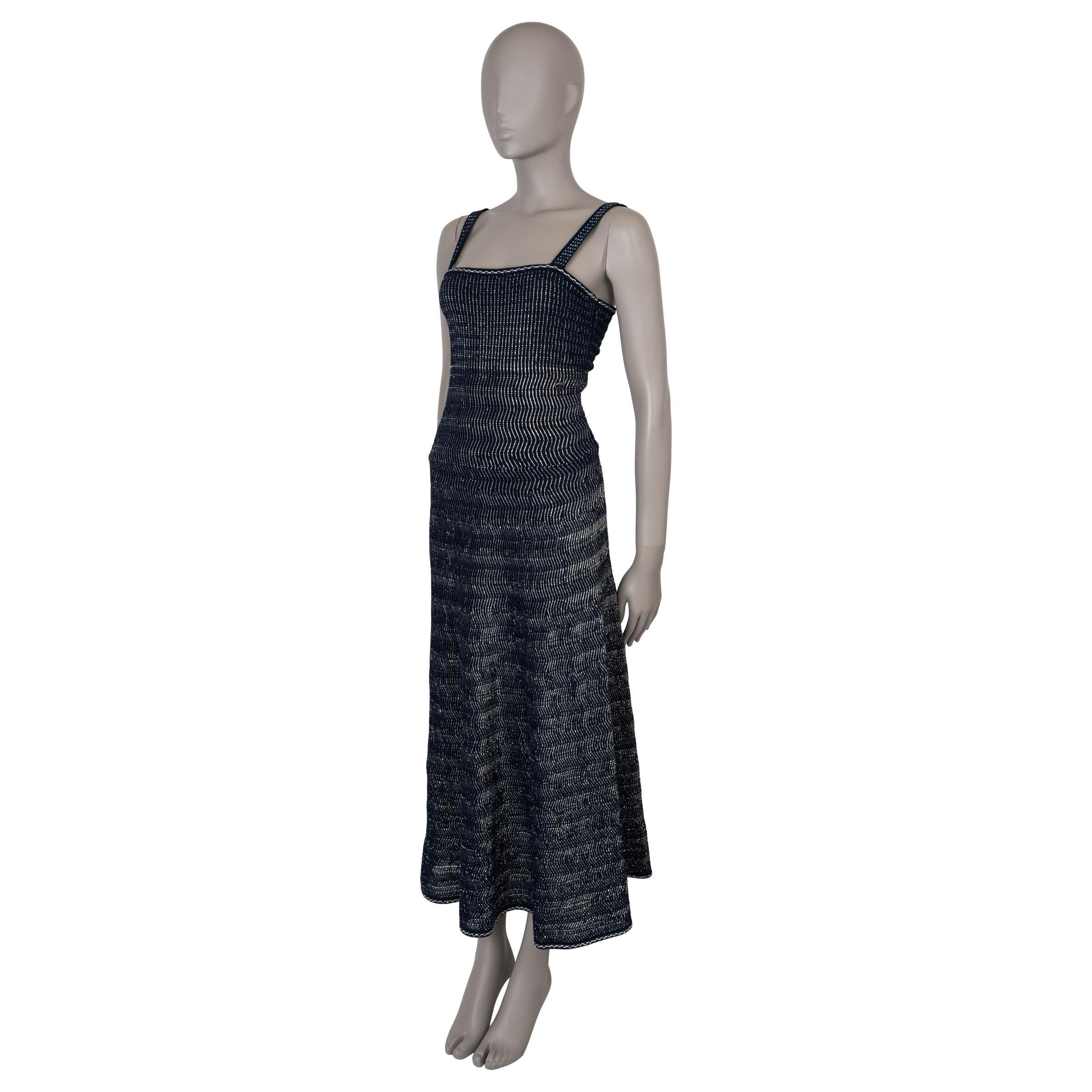 This 100% authentic Chanel maxi knit dress in navy blue is crafted from a luxurious blend of cotton (65%), polyamide (31%), viscose (2%), and paper (2%), subtly woven with silver lurex for a touch of shimmer. It features a fitted, sleeveless top and