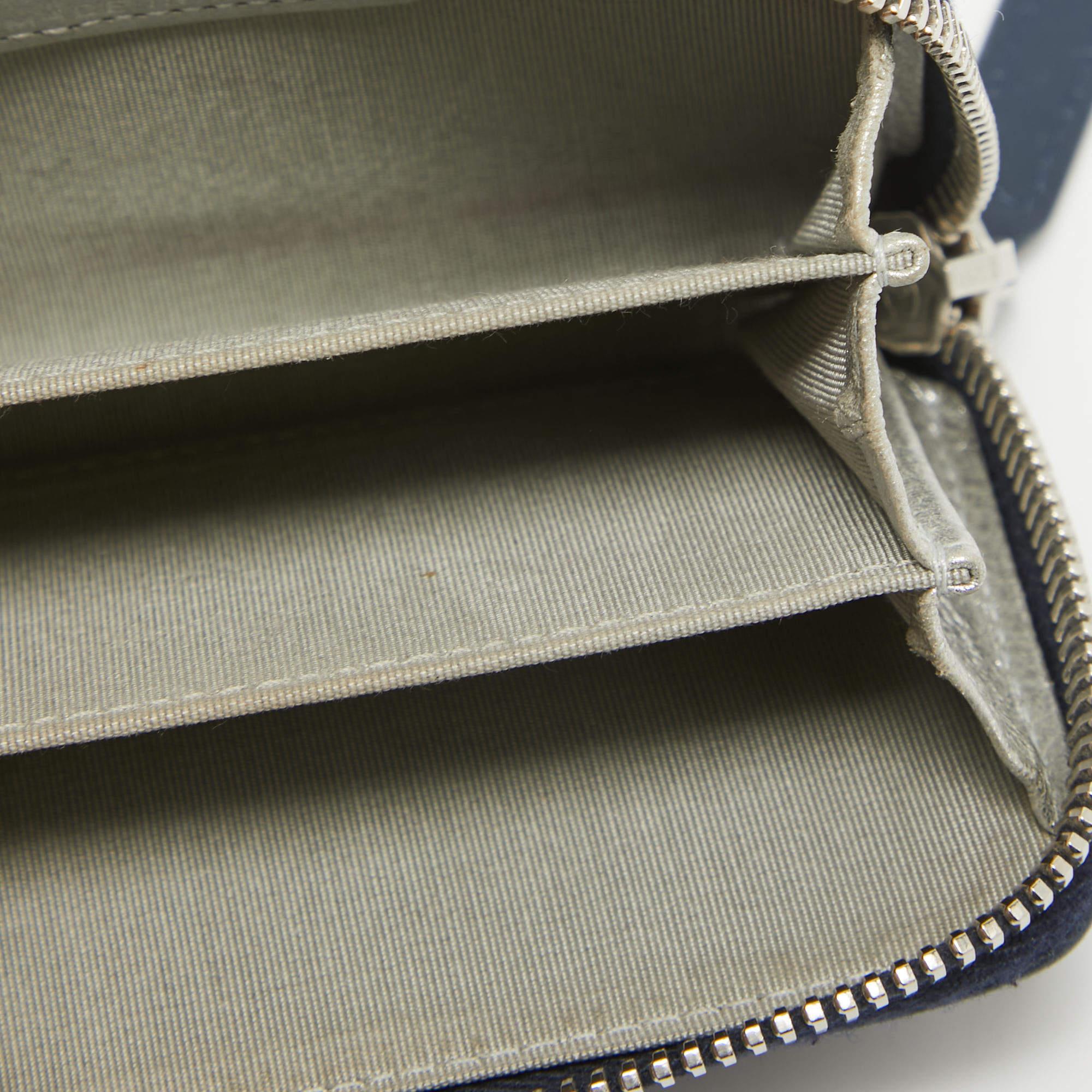 Crafted using leather this Chanel coin purse will help carry your coins and other little essentials with ease. It comes in a lovely dark blue hue and is lined with fabric.