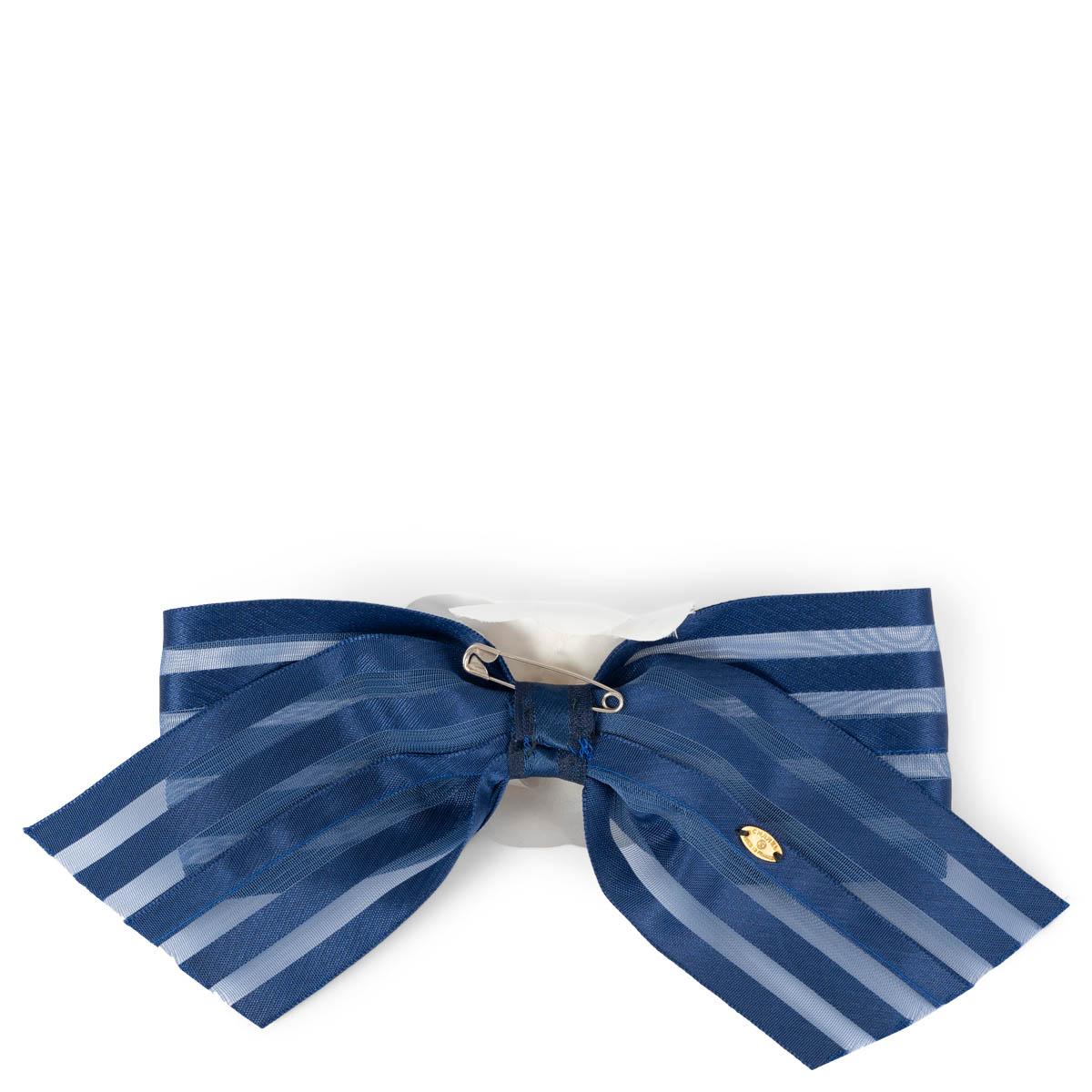 100% authentische Chanel Kamelien-Brosche aus weißer Baumwolle auf einer gestreiften marineblauen flachen Seidenschleife. Wurde getragen und ist in ausgezeichnetem Vintage-Zustand. 

Messungen
Breite	7cm (2.7in)
Höhe	18cm (7in)

Alle unsere Angebote