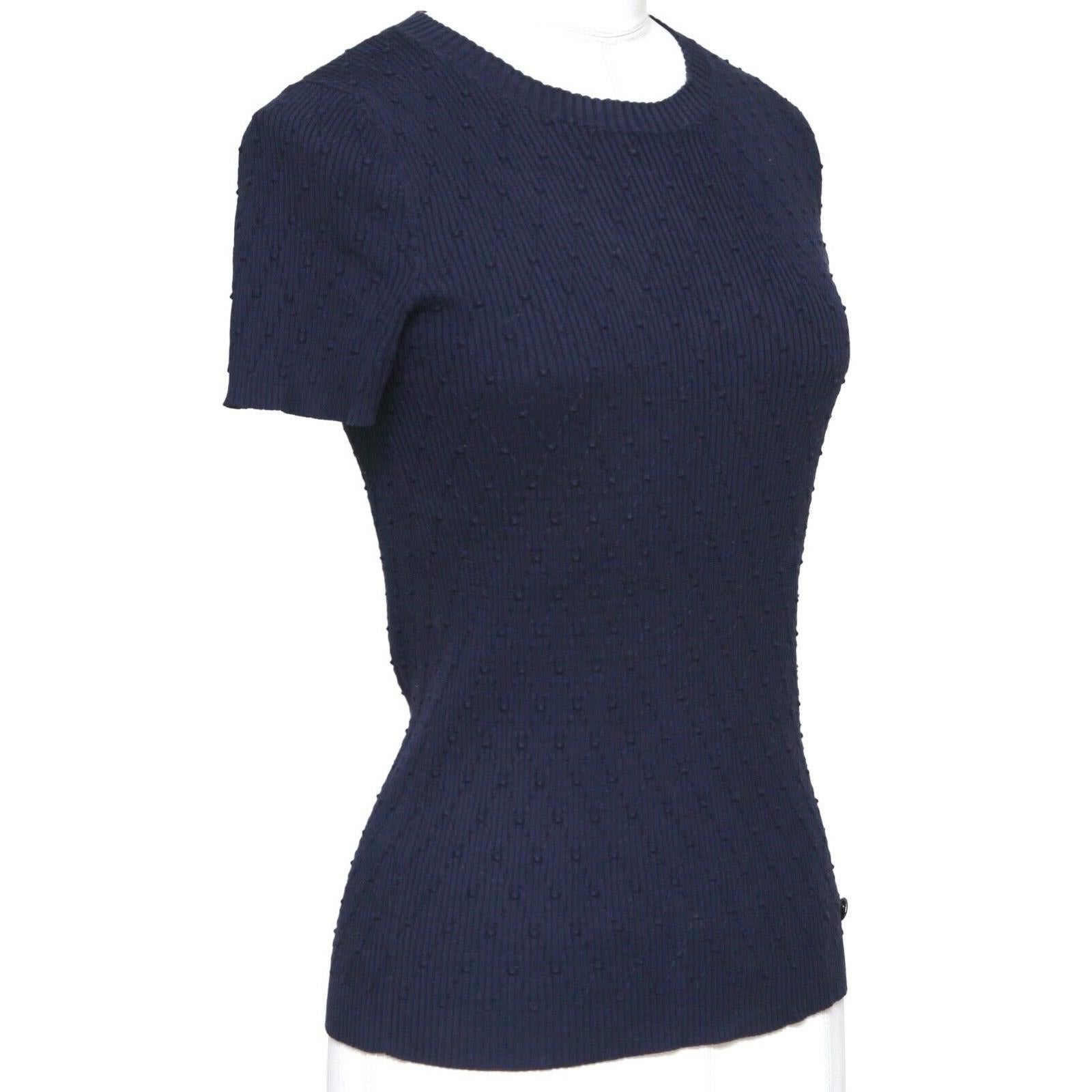 GUARANTEED AUTHENTIC CHANEL NAVY BLUE SHORT SLEEVE DIAMOND QUILTED PATTERN TOP

Design:
- Versatile short sleeve diamond quilted pattern knit top in a rich navy blue color.
- Crew neck.
- Slip on.
- CC logo at left hip.

Size: 34

Measurements