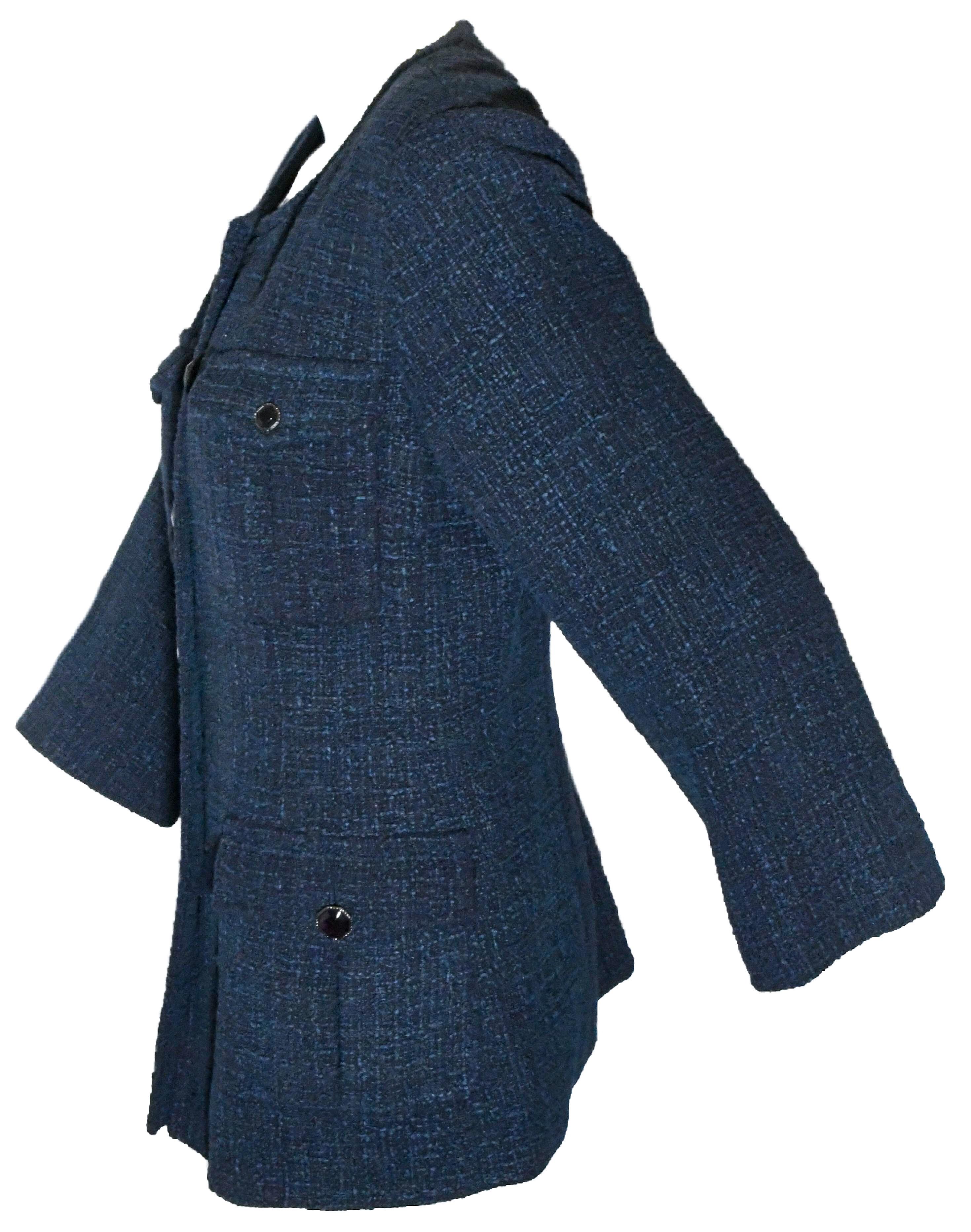 Chanel blue tweed jacket has 4 front flap pockets that feature signature gripoix purple stone button.  The round neckline collarless jacket incorporates 6 purple gripoix buttons for front closure and has single rear vent and flared cuffs.  Fully