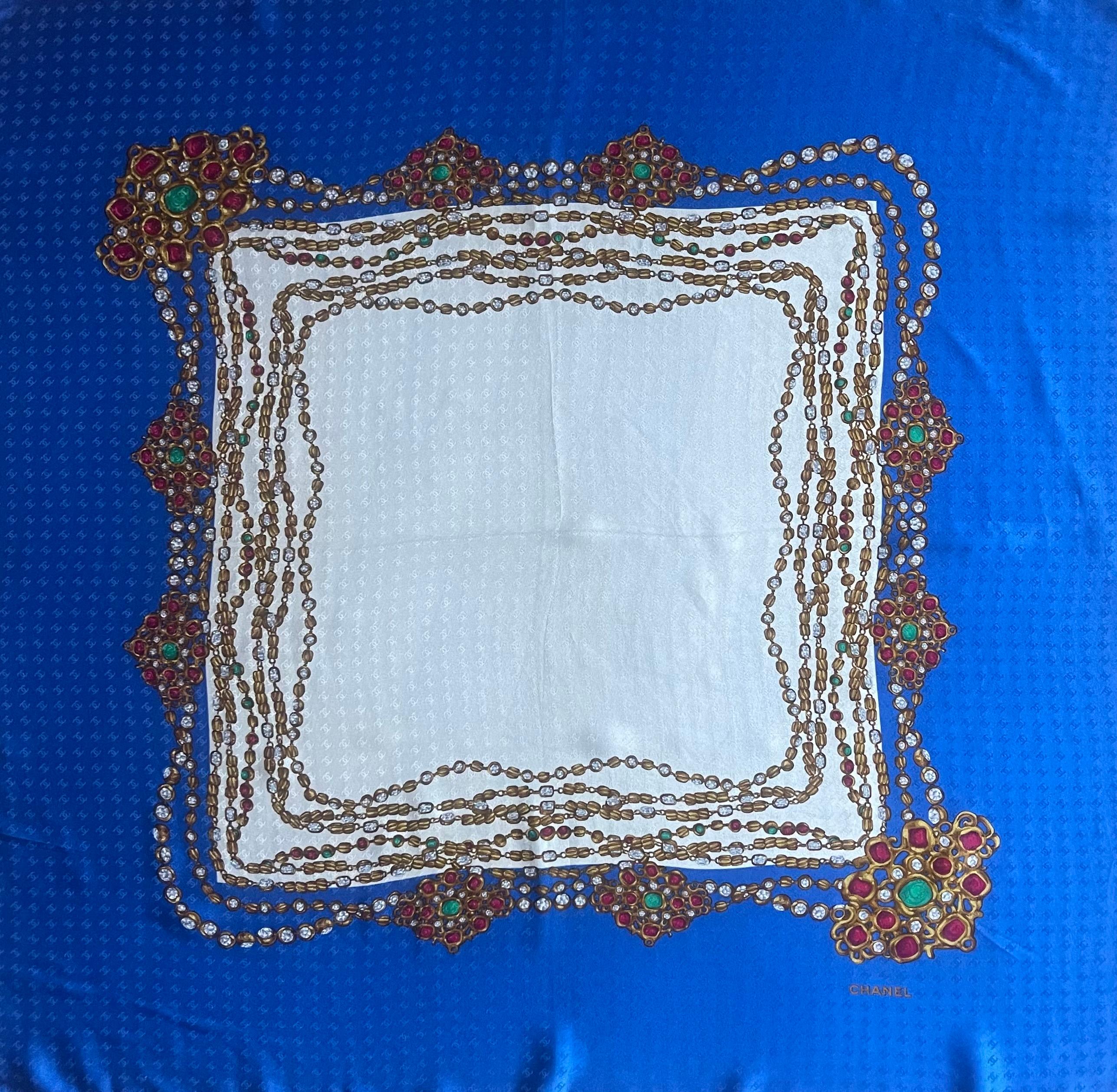Sciarpa Chanel in seta blu e bianca con catena Gripoix. Questo bellissimo foulard rappresenta perfettamente l'attenzione di Chanel per i dettagli e la creatività e l'arte di tutte le sue collane. Pezzo iconico da aggiungere alla tua collezione,