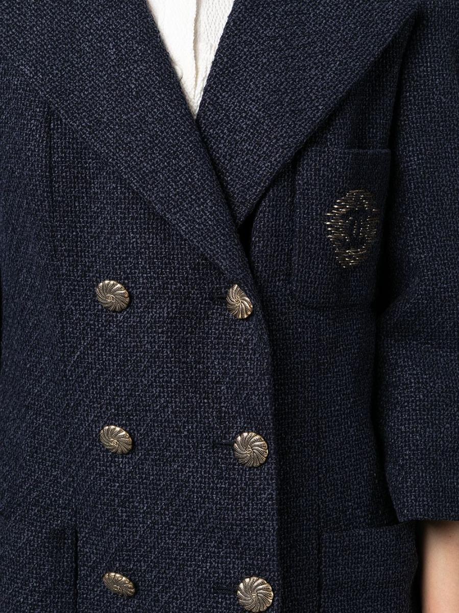 Crafted from cotton tweed, this elegant pre-owned Chanel black and navy blazer features a CC gold embroidered logo at the chest, a double-breasted front closure and a 3/4 sleeve length. Its details include a silk lining featuring the brand's