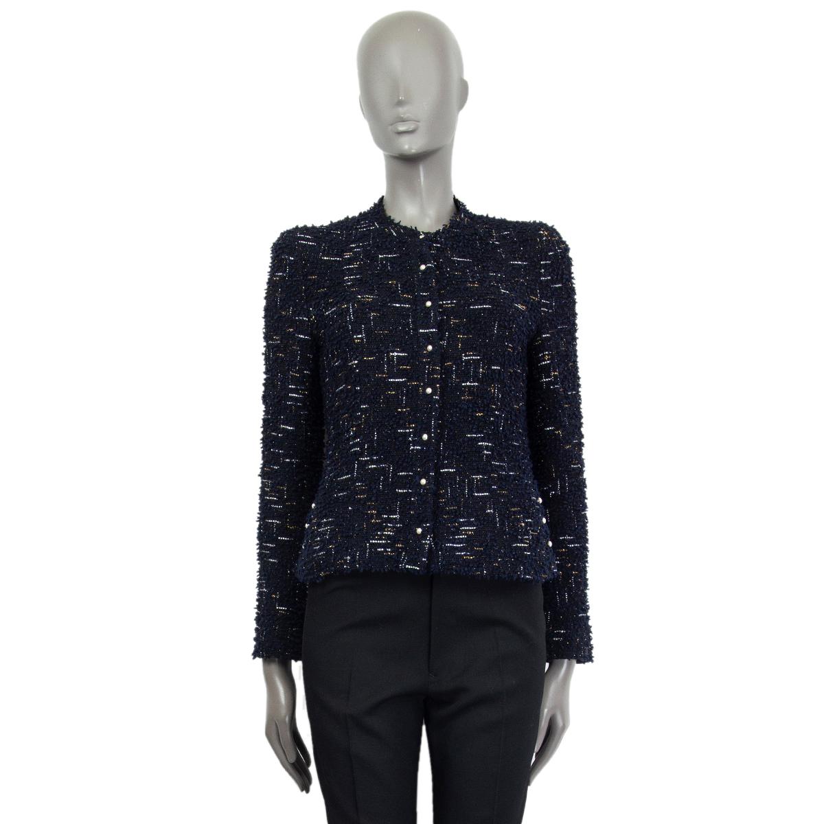 Chanel collarless tweed jacket in navy blue and black polyamide (61%), polyester (27%) and wool (12%) with silver and gold lurex threads. Faux pearl button details on the front, sleeve and sides. Lined in black silk (100%) with antique silver-tone