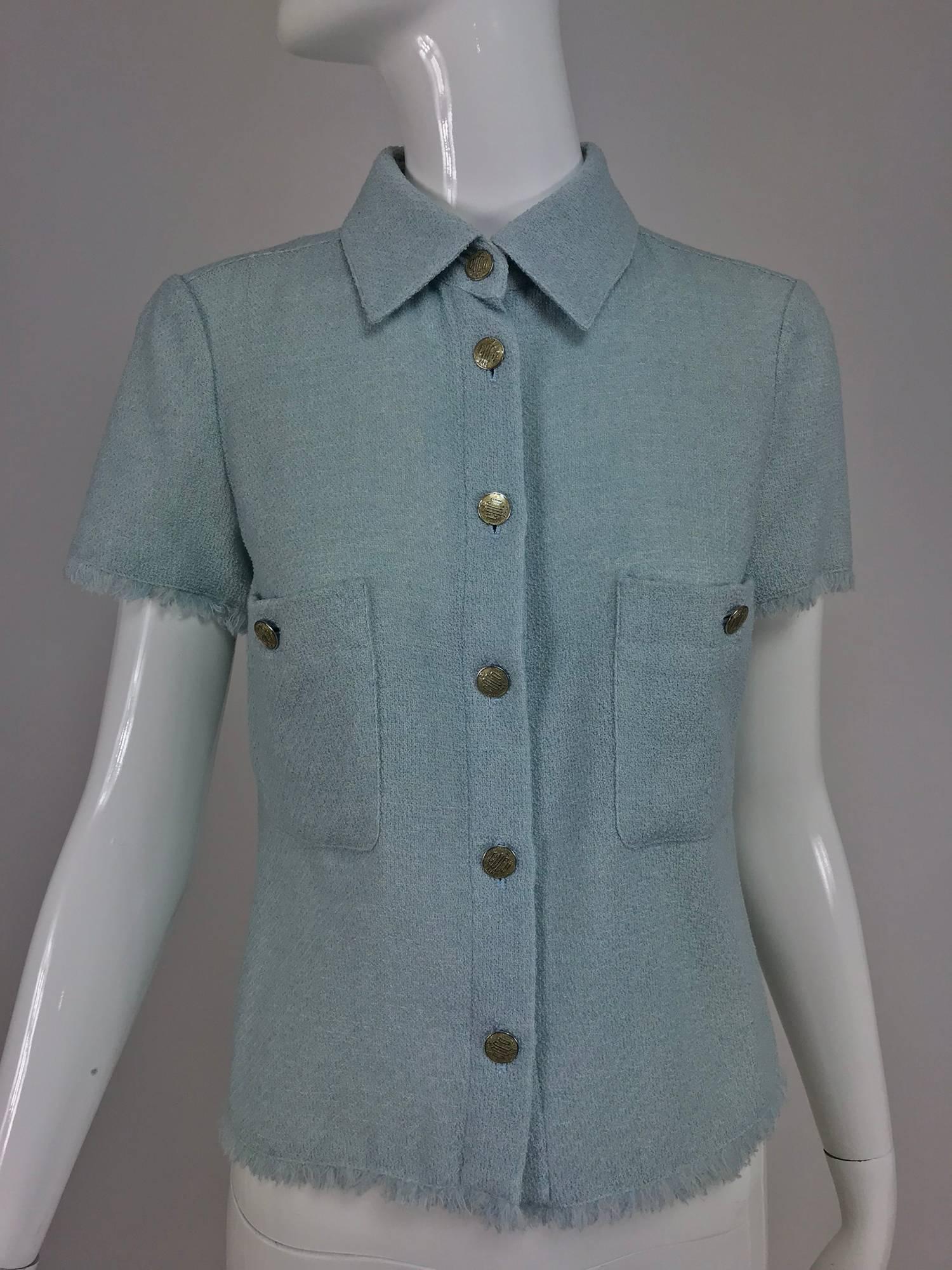 Chanel blue wool crepe short sleeve jacket 08C...Dusty blue wool crepe, short sleeved, unlined jacket...Fringe trimmed cuffs and hem...Button front with silver and gold enamel Coco buttons...Two breast button through patch pockets...Marked size 36,