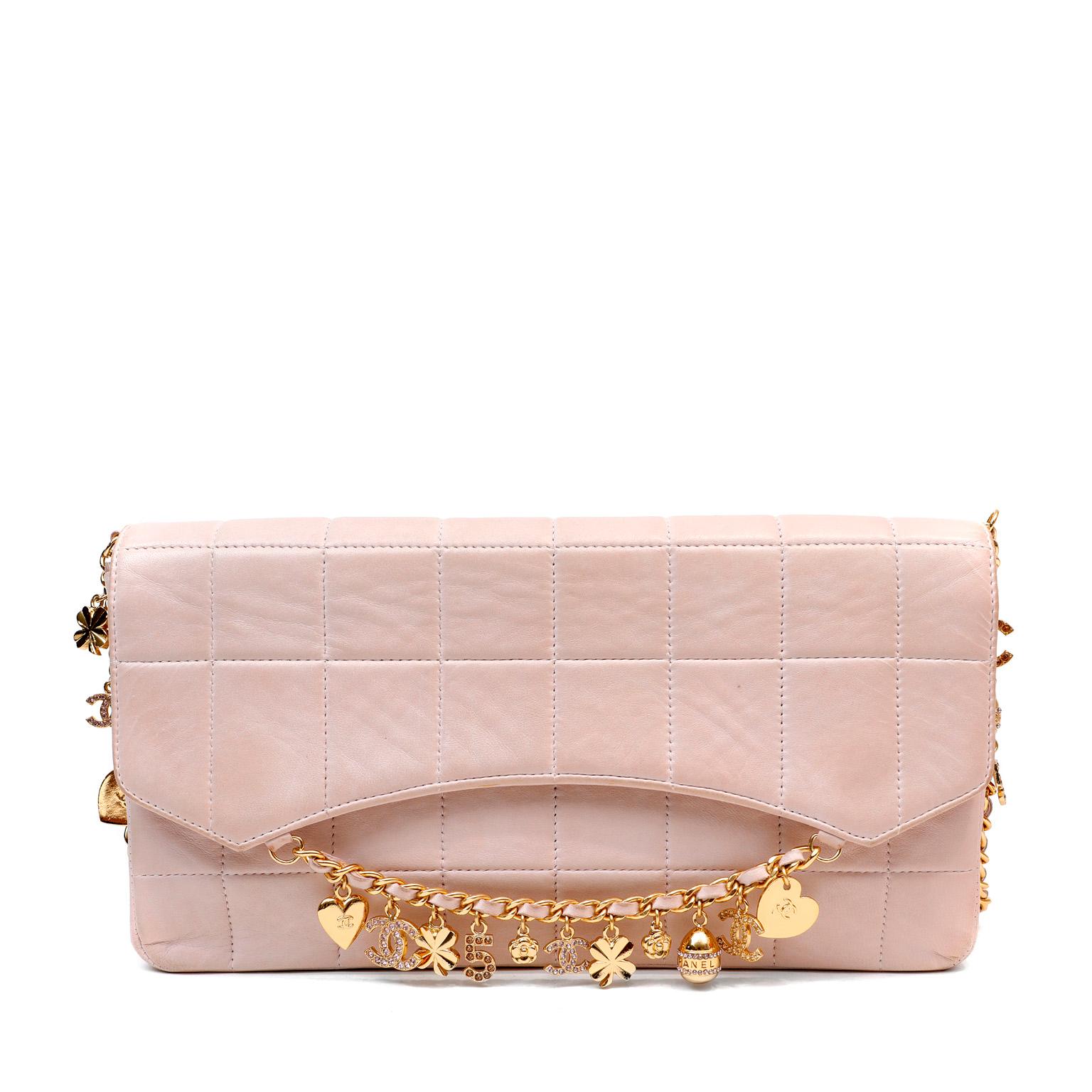 This authentic Chanel Blush Lambskin Lucky Charms Chain Flap Bag is in pristine condition.  A beautiful and feminine design, this collectible bag features iconic Chanel symbols that dangle decoratively from both the flap and strap.  Blush pink
