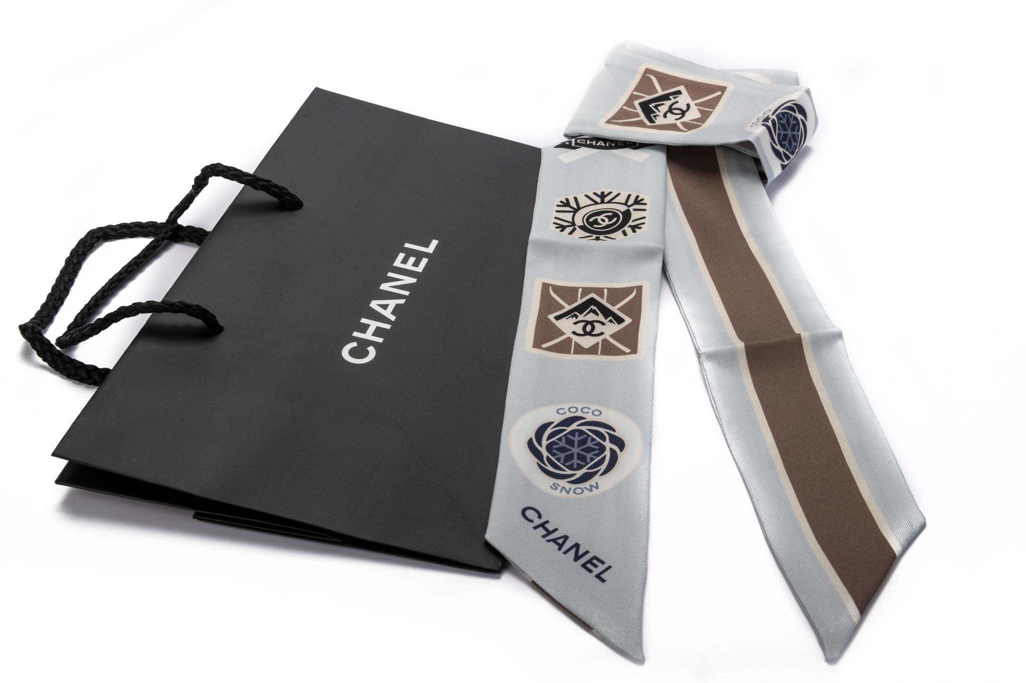Chanel brand new 100% silk twilly scarf. Coco niege collection with snow flakes. Gray base color with blue and white detail. Chanel shopper not included.