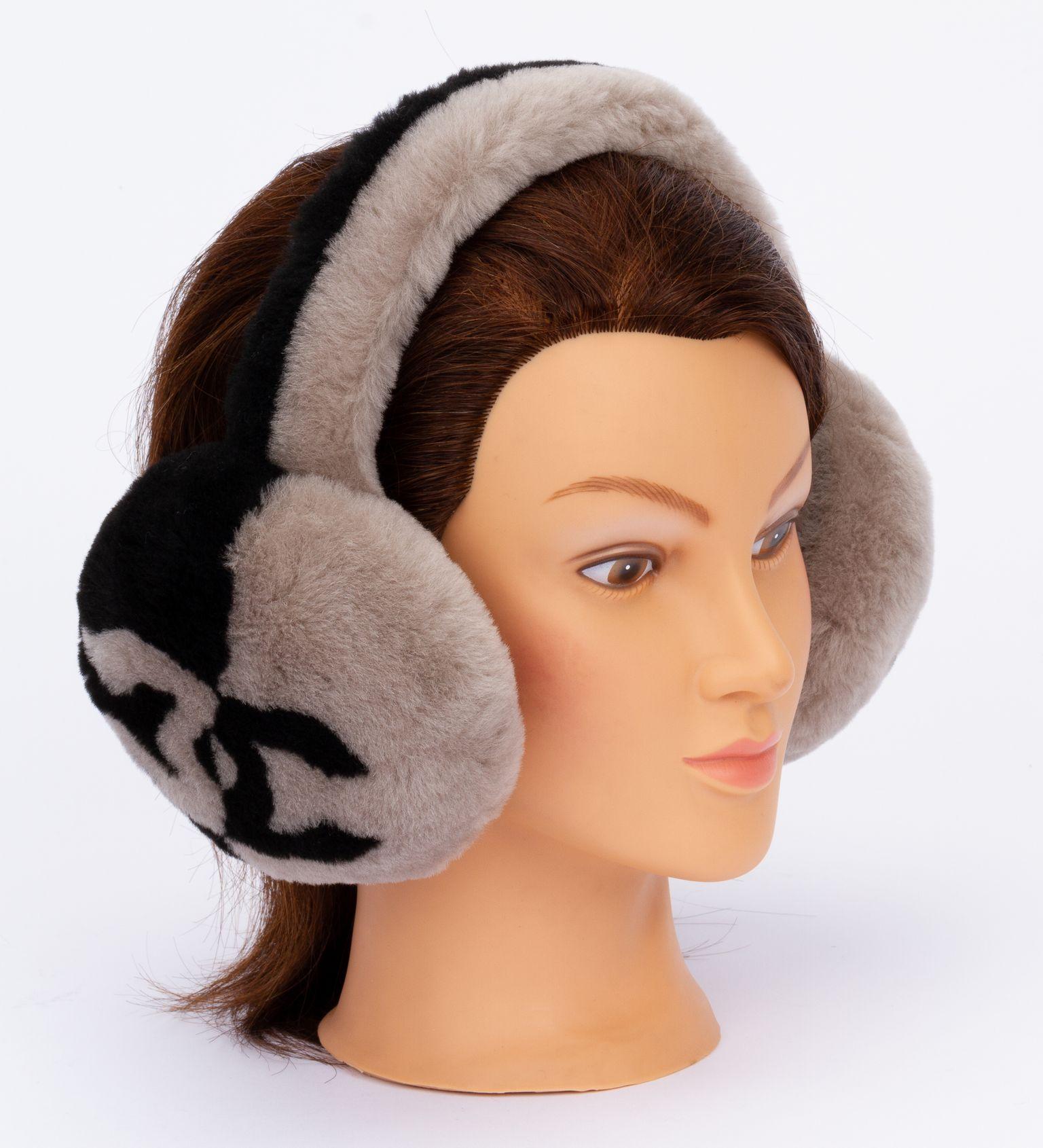 Original Chanel CC Shearling Ear Muffs in black and taupe. The earmuffs are made out of shearling and have a CC logo on each side. The piece comes in the original box and is brand new.