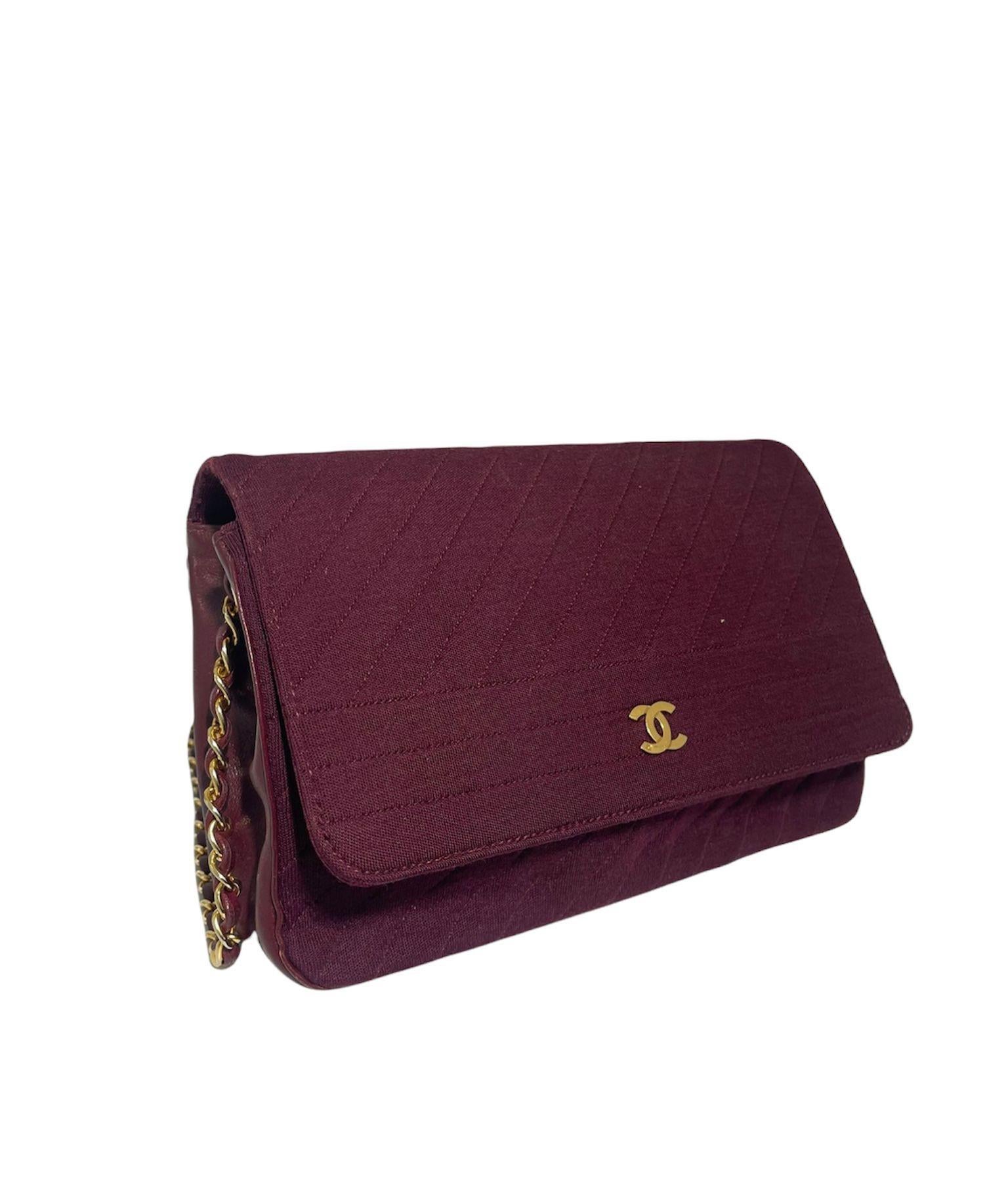 Chanel signed bag, vintage model, made of burgundy fabric with side leather inserts and golden hardware. Equipped with a button closure, internally lined in blue fabric, quite roomy. Equipped with a leather and chain shoulder strap and an inside
