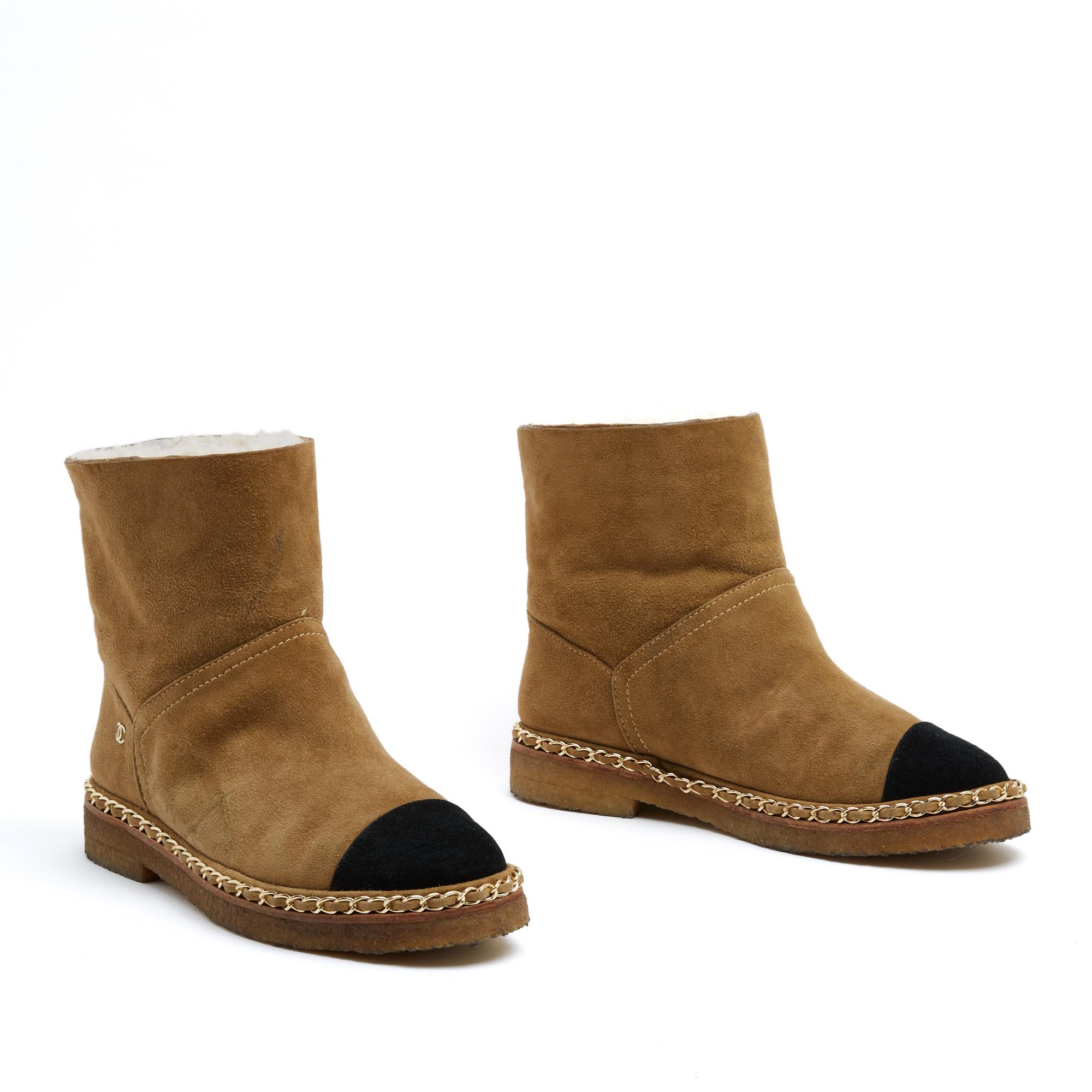 Stivaletto Chanel a metà polpaccio in camoscio cammello foderato in shearling, punta a mandorla in camoscio nero, suola in gomma crepla circondata da una catena in metallo dorato intrecciata con il camoscio in tinta. Taglia 36 EU (UK 3.5, US 6). La