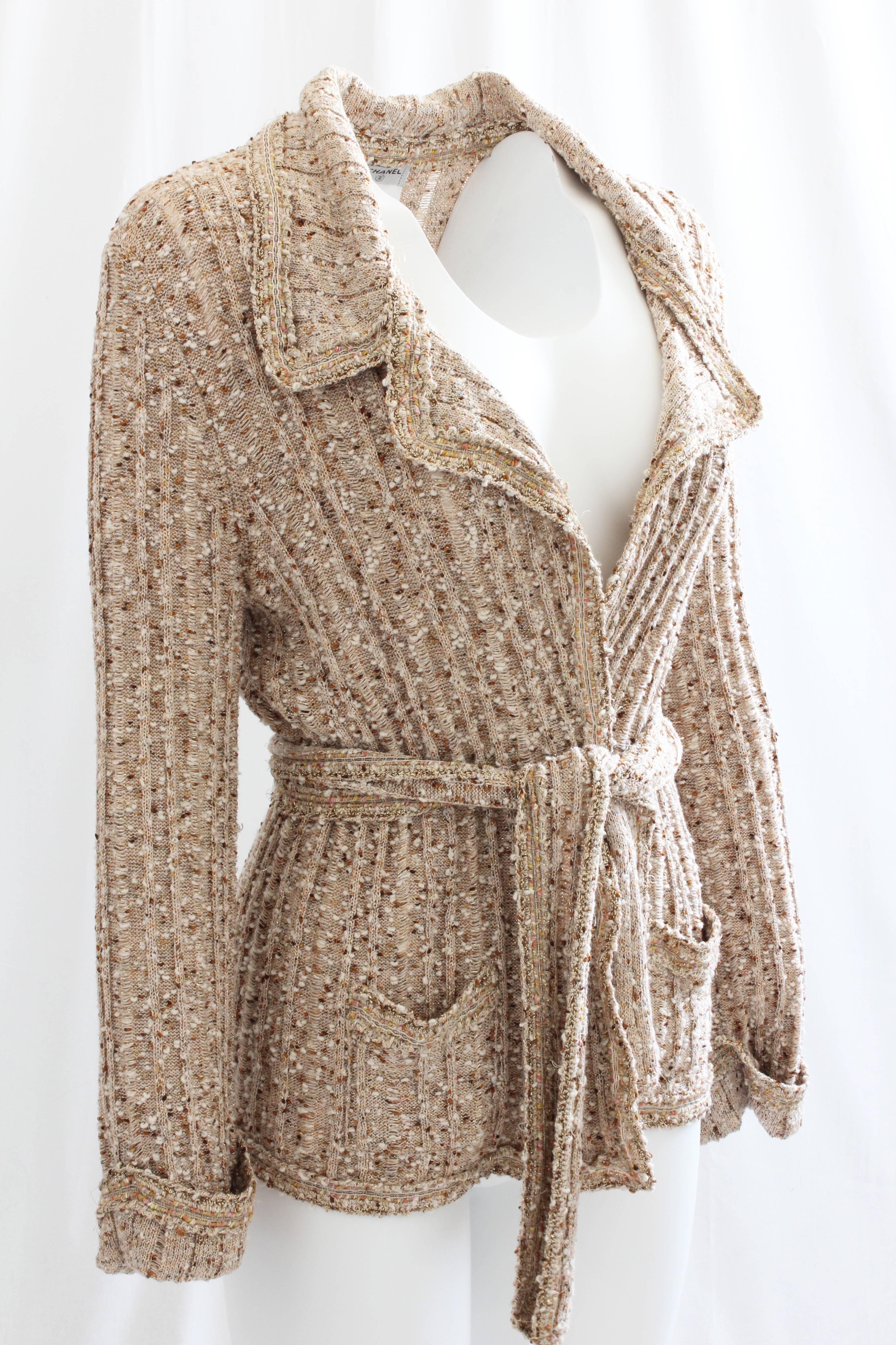 Here's a lovely wrap-style cardigan with belt from Chanel. From their 06P collection, this piece is made from a cotton blend boucle, is unlined and fastens wrap-style with it's included matching belt. In excellent preowned condition. Tagged size 44,