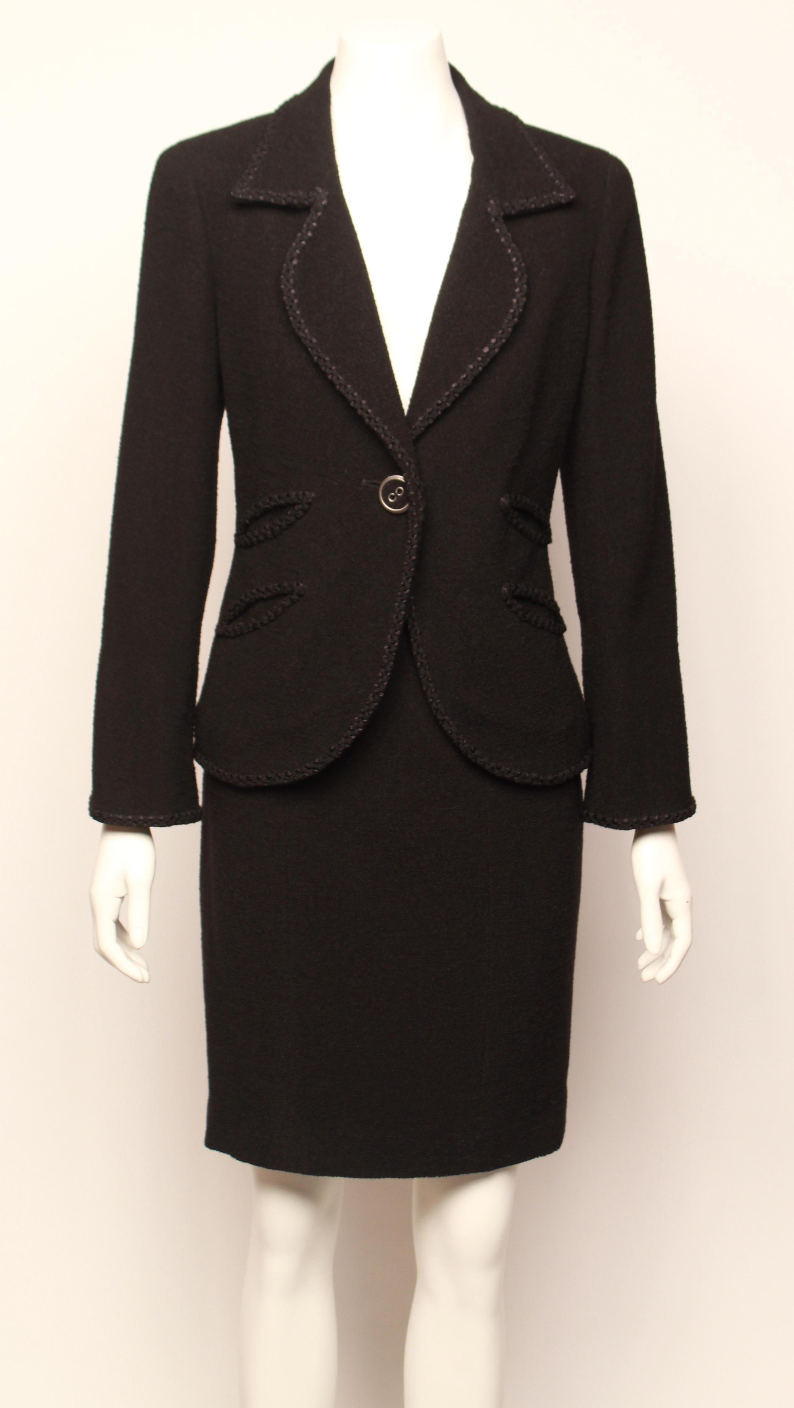 Classic and elegant CHANEL boucle' skirt suit ensemble features single breasted jacket with petal shaped collar, braid edging and decorative button closure. Fully lined in signature embossed silk lining. 
Knee length pencil skirt is panelled and