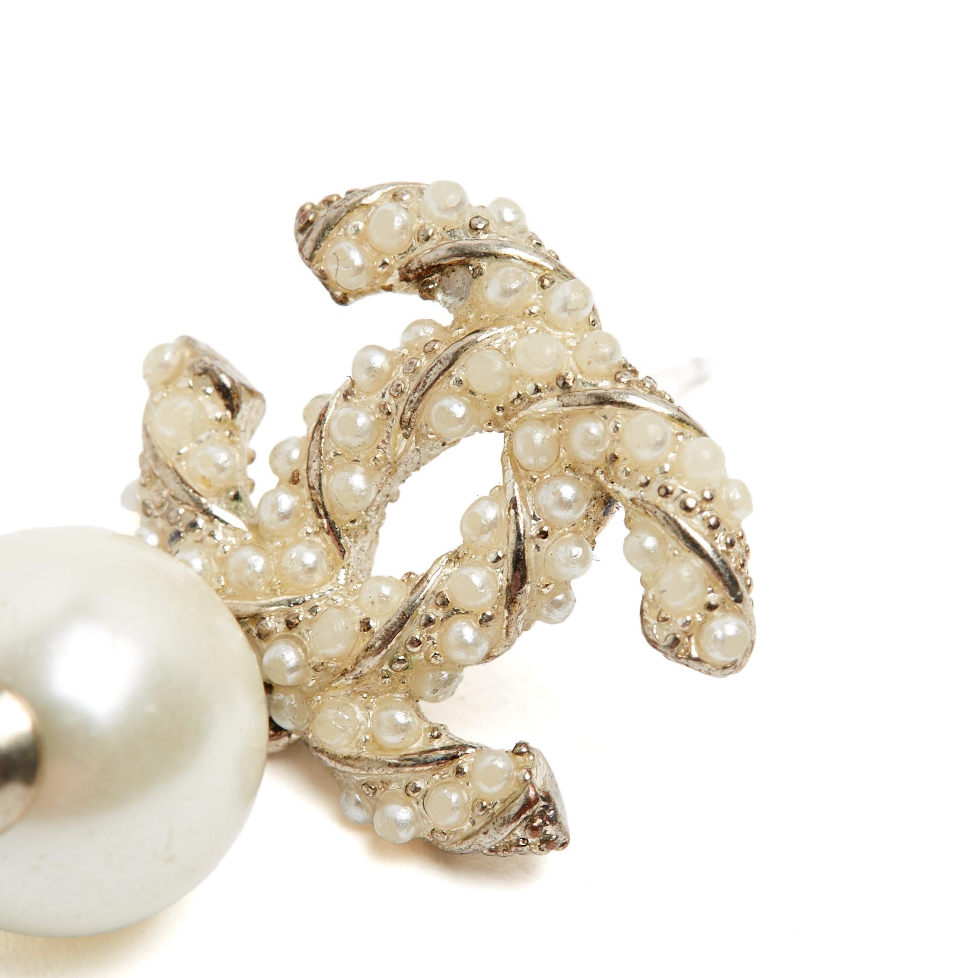 Chanel single earring (not a pair) 2016 in silver metal with the twisted CC logo motif inlaid with fancy micro pearls and fancy pearl pendant. Width 1.65 cm x height 2.95 cm. The earring comes without invoice or original packaging, and the micro