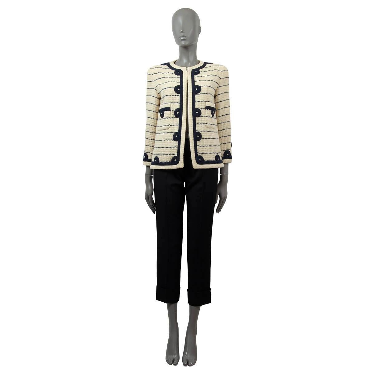 100% authentic Chanel Boutique striped open tweed blazer in ivory and navy blue wool blend (missing tag). The design features softly padded shoulders, two front patch pockets and on hook closure. Lined in ivory silk. Has been worn with some
