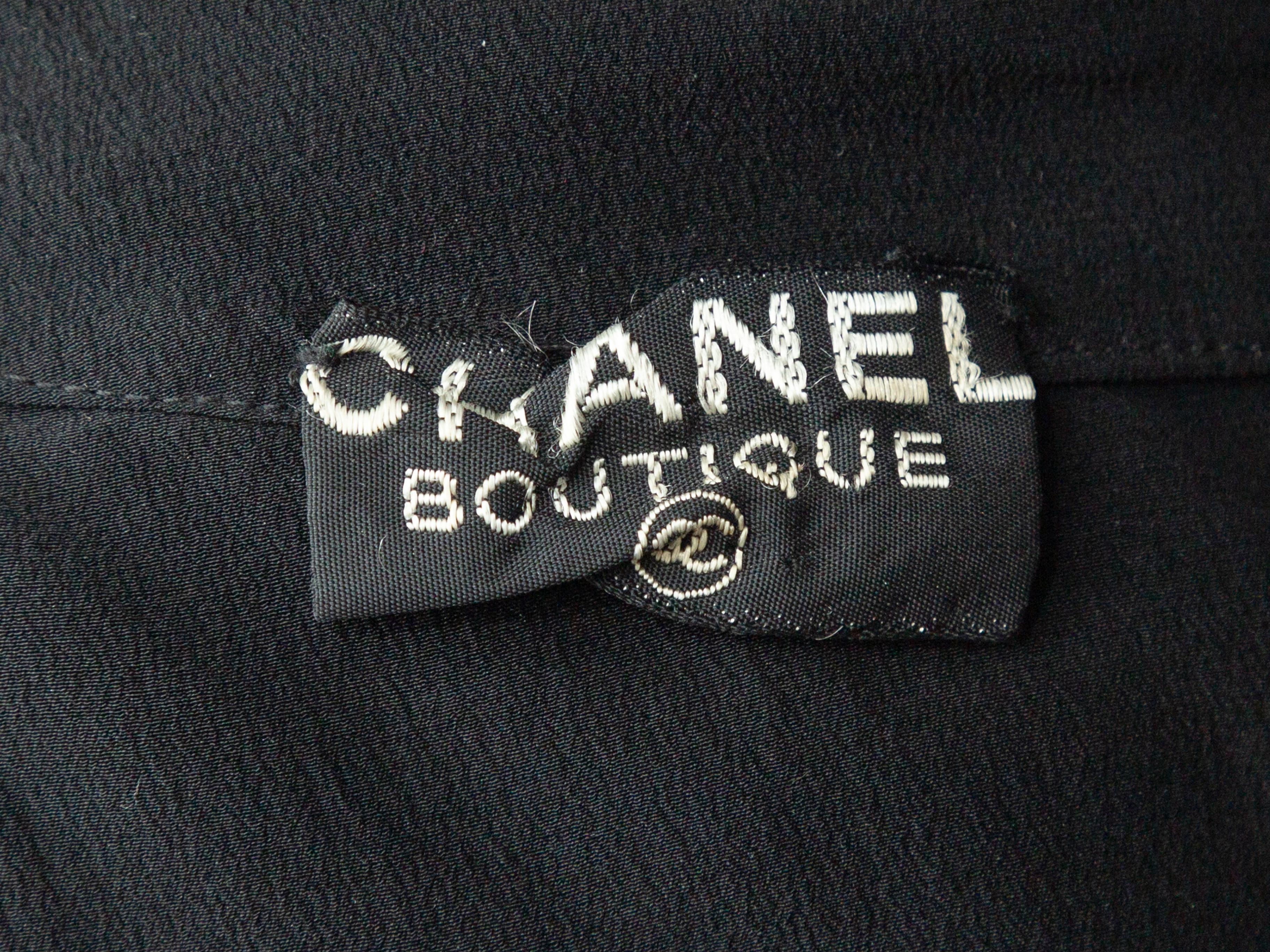 Product details: Vintage black sleeveless pleated top by Chanel Boutique. Round neckline. Button closures at center back. 30
