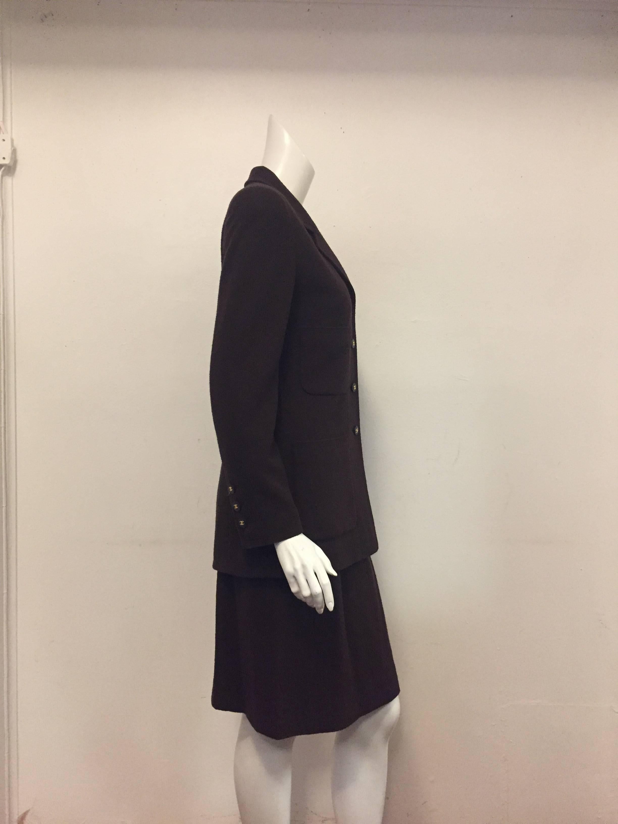 Chocolate Wool Blend Skirt Suit illustrates why Chanel suiting is the ultimate in investment dressing!  Weighted with a graphite tone chain, single breasted jacket features slightly padded shoulders, notched lapel, and four patch pockets. Sleeves