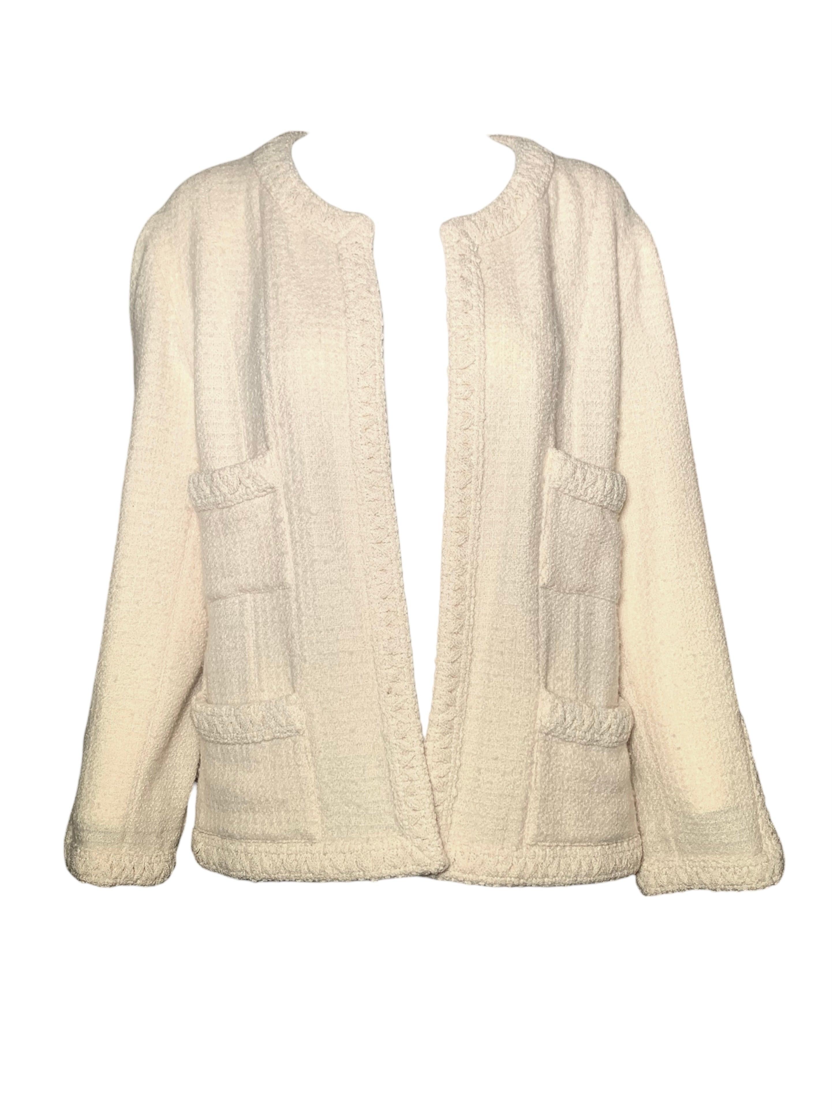 Classic Chanel cream skirt suit. Boucle tweed wool in a buttery shade of cream. The open cardigan jacket has no closure. Mid length skirt with side zipper and hook closure. The jacket is adorned with two large pockets. The skirt has a slit with a
