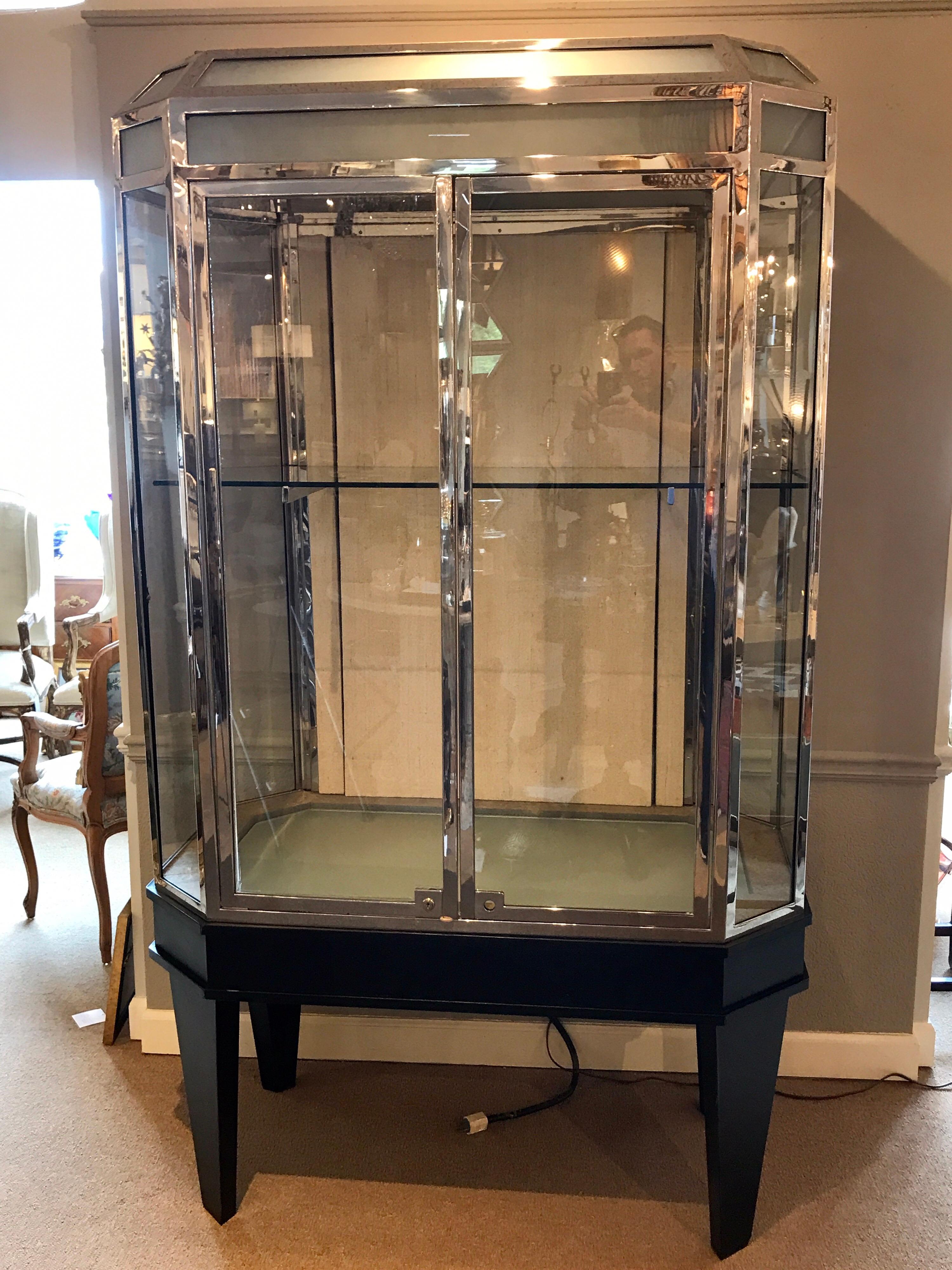 Modern chrome and ebonized display case from Chanel, two available. Each one of hexagonal form of polished chrome, frosted and clear glass, lighted top and bottom. Fitted with two drawers and one 18
