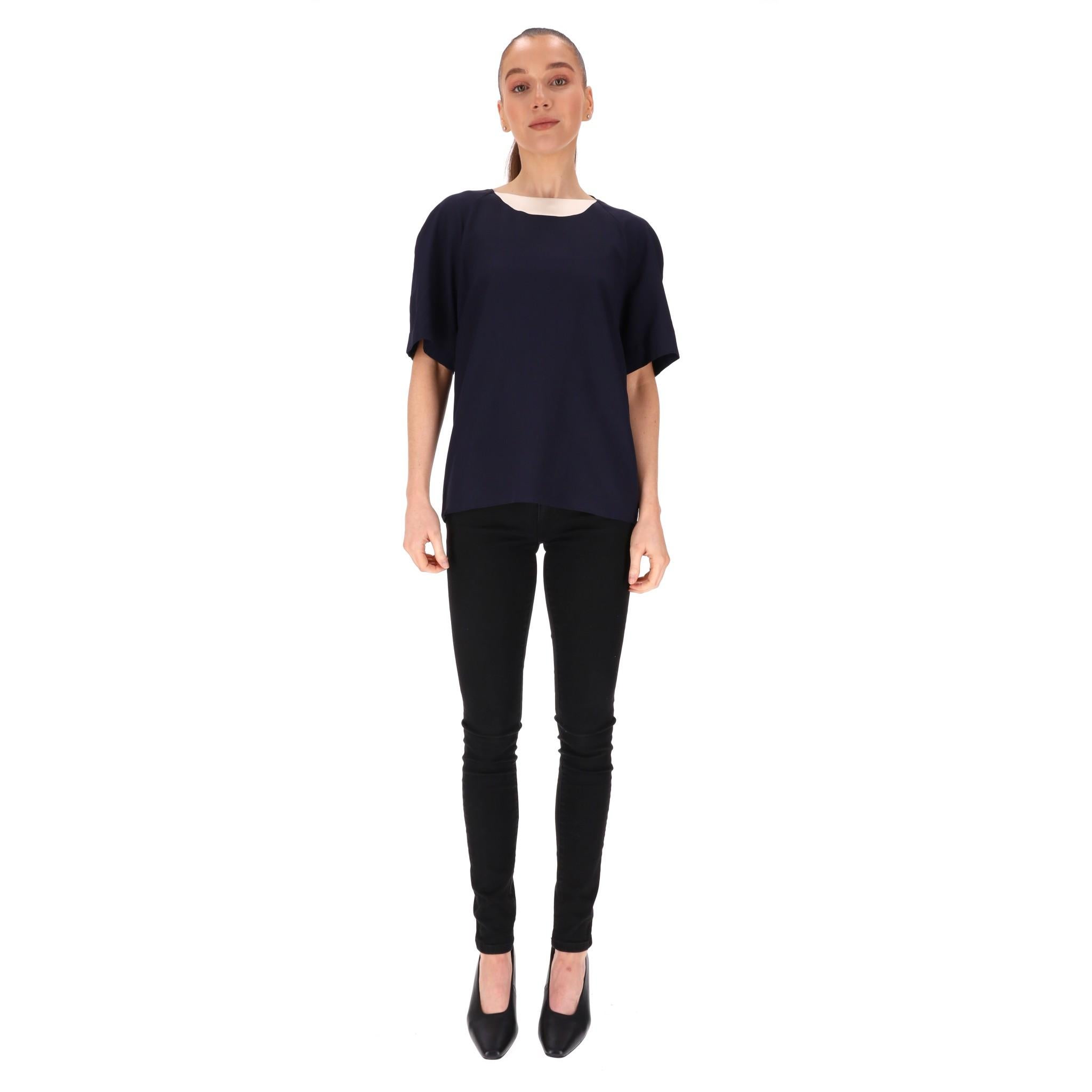 Chanel Boutique Vintage Silk Top

Navy blue with contrasting nude/beige trim to the neckline and finished with a gold 'Chanel No5 Perfume Bottle' button to the key hole closure

Size - 36FR (Label missing but corresponds)

Condition - Vintage -