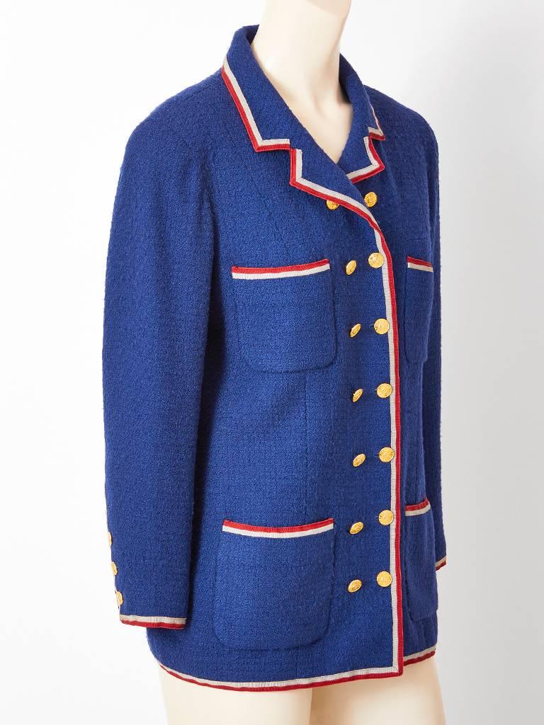 Chanel Boutique, cadet blue, wool bouclé, double breasted jacket having a notched collar, 4 pockets and grey and red grosgrain trim detail. C. Early 80's.
