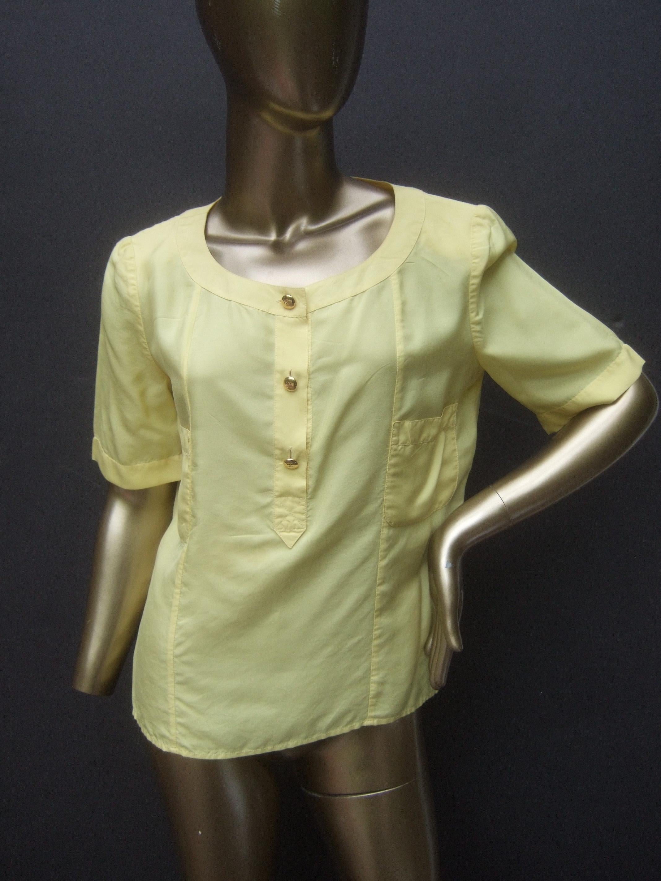 Chanel Boutique Yellow silk blouse with Chanel gilt metal buttons French Size 38

The luxurious breezy light-weight sheer short sleeve silk blouse is adorned with three Chanel gilt metal C.C. initial buttons that partially run down the