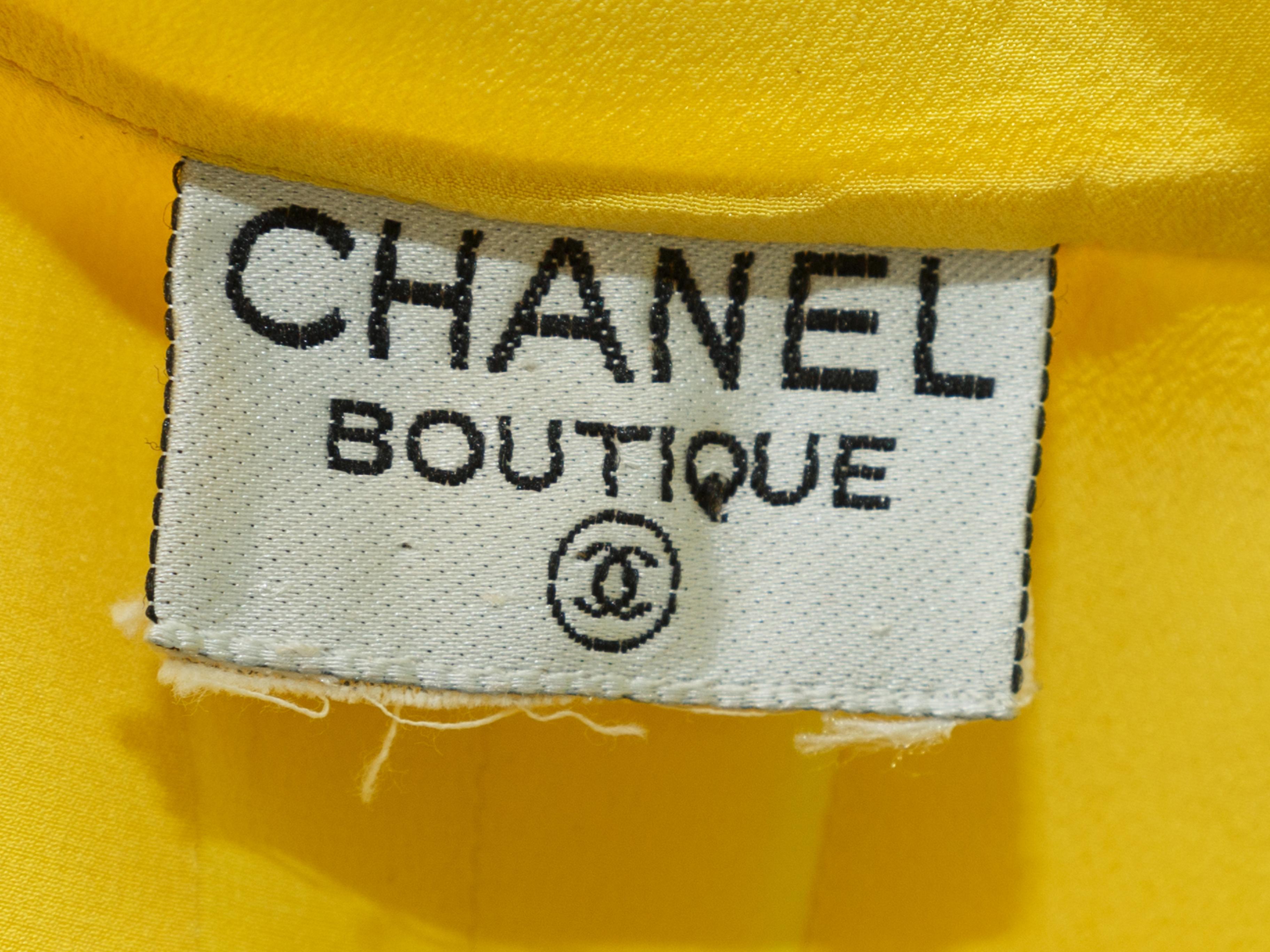 Product details: Vintage yellow silk sleeveless pleated top by Chanel Boutique. Round neckline. Fitted waist. Gold-tone CC button closures at front. 34