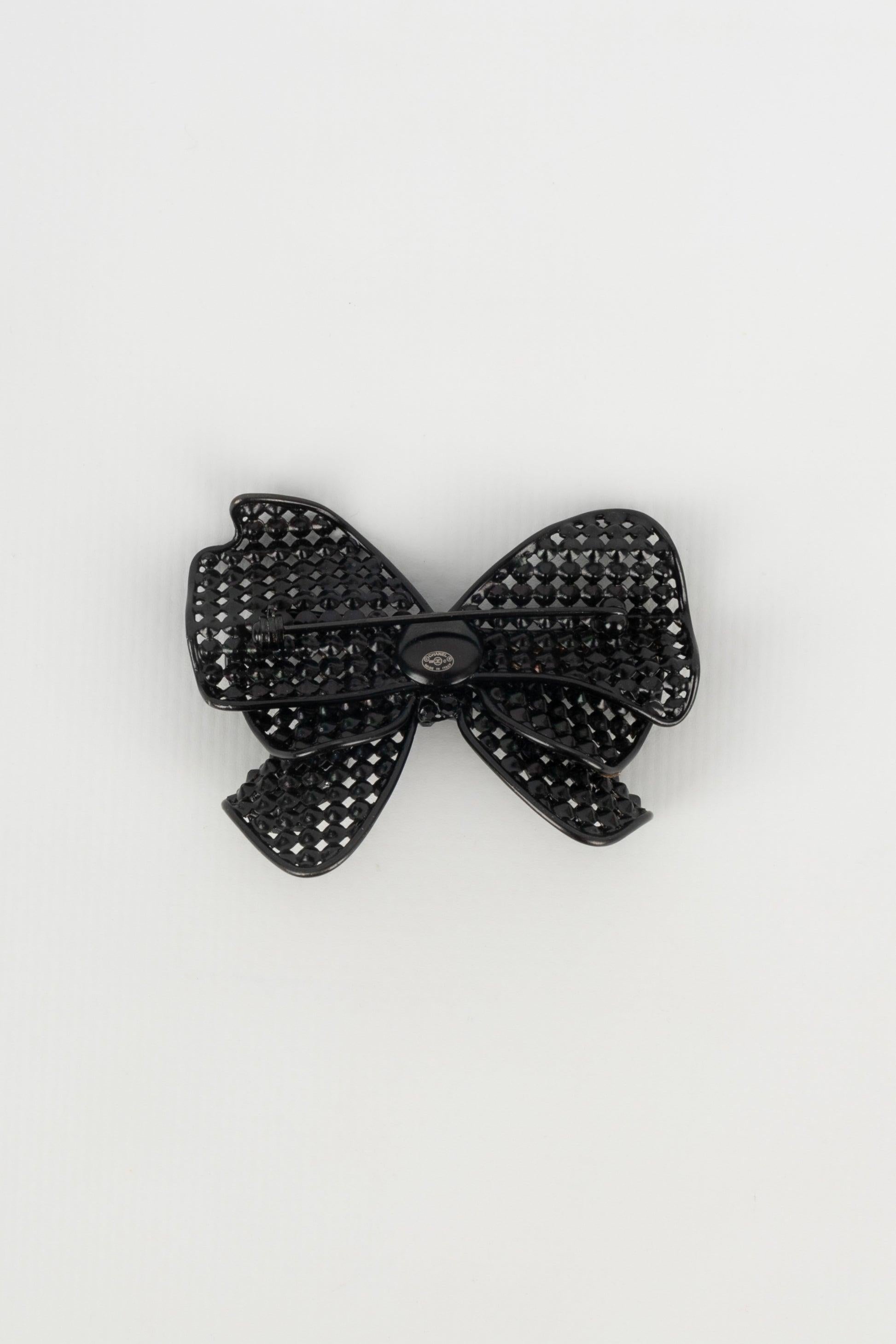 Chanel - (Made in Italy) Black metal brooch representing a bow ornamented with black rhinestones. Cruise 2009 Collection.

Additional information:
Condition: Very good condition
Dimensions: Length: 5.5 cm
Period: 21st Century

Seller Reference: