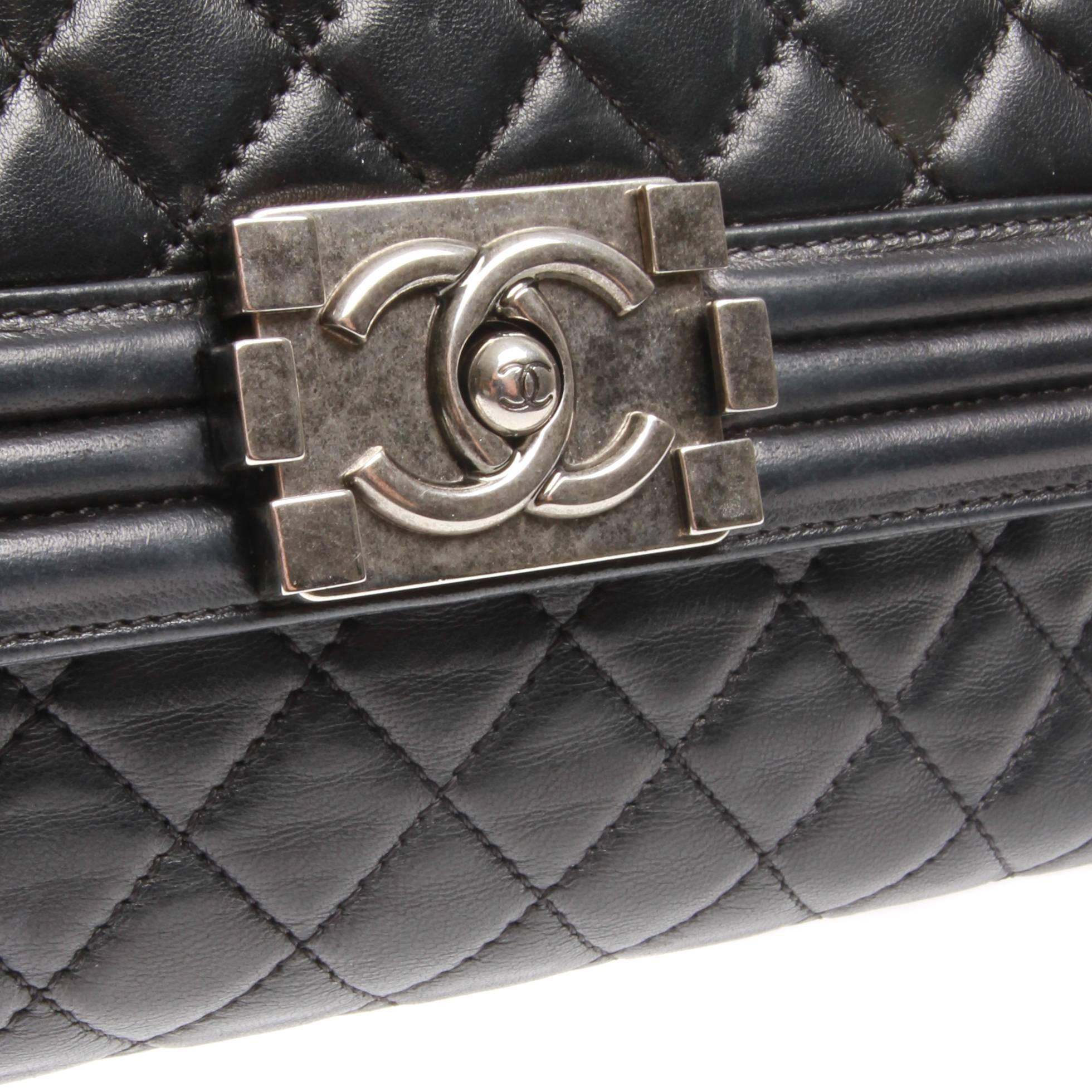 Black quilted leather Chanel Boy Accordion Flap bag with antique silver-tone hardware, gathered chain-link shoulder straps featuring shoulder pad, exterior pock with snap closure at back, grey woven lining, three pockets at interior wall; one with