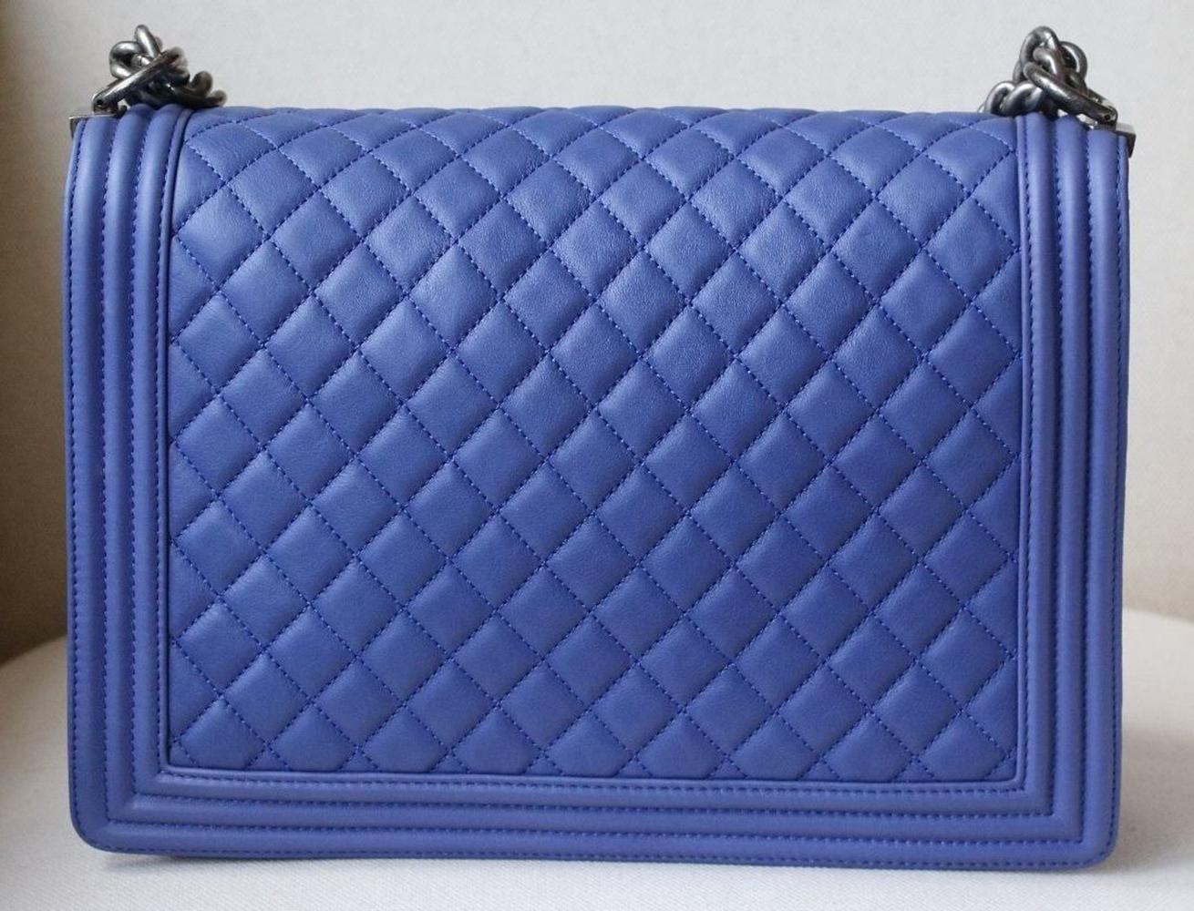 This Chanel Boy Large Flap bag in grained calfskin quilted leather features a signature double CC push lock closure, as well as signature chain and leather straps. Gunmetal hardware.

Dimensions: Approx. 21 cm x 30 cm x 8 cm

Condition: Barely used.