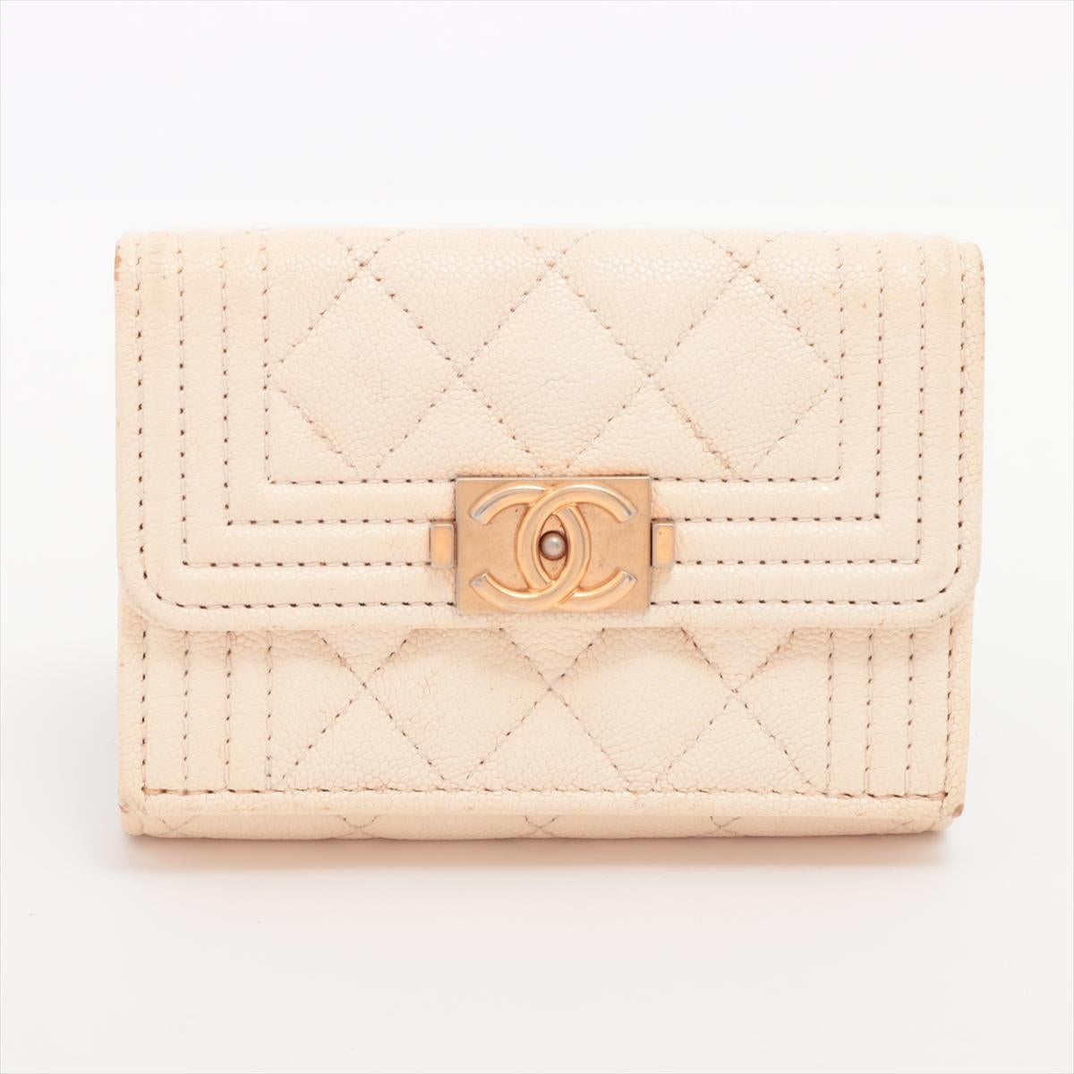 The Chanel Boy Chanel Caviar Skin Compact Wallet in Ivory is a timeless and sophisticated accessory that combines luxury with practicality. Crafted from durable caviar leather, the compact wallet features the signature Boy Chanel quilted design with