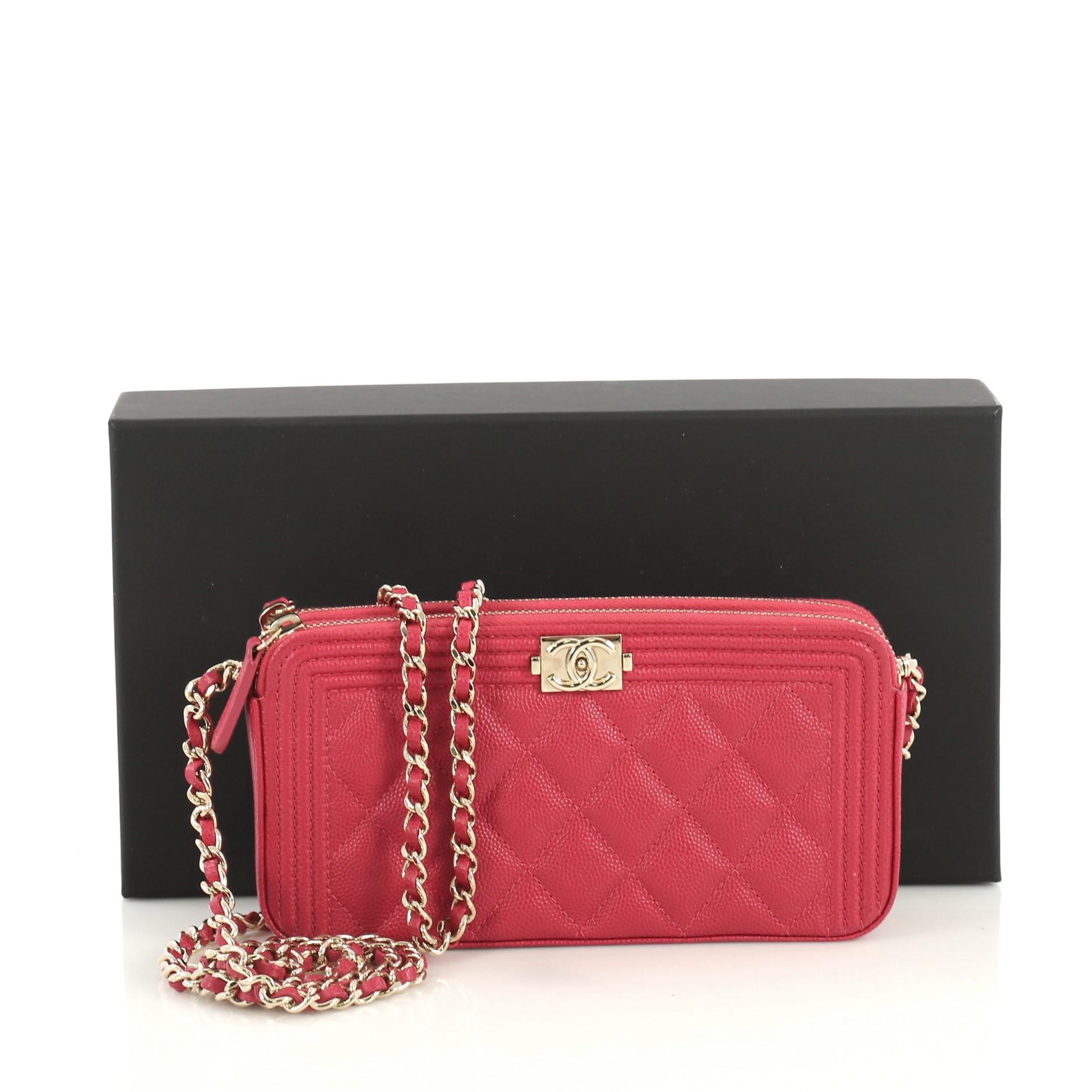 This Chanel Boy Double Zip Clutch with Chain Quilted Caviar, crafted from pink quilted caviar leather, features woven-in leather chain link strap, two zip compartments, and gold-tone hardware. Its two zip closures open to a pink fabric interior.