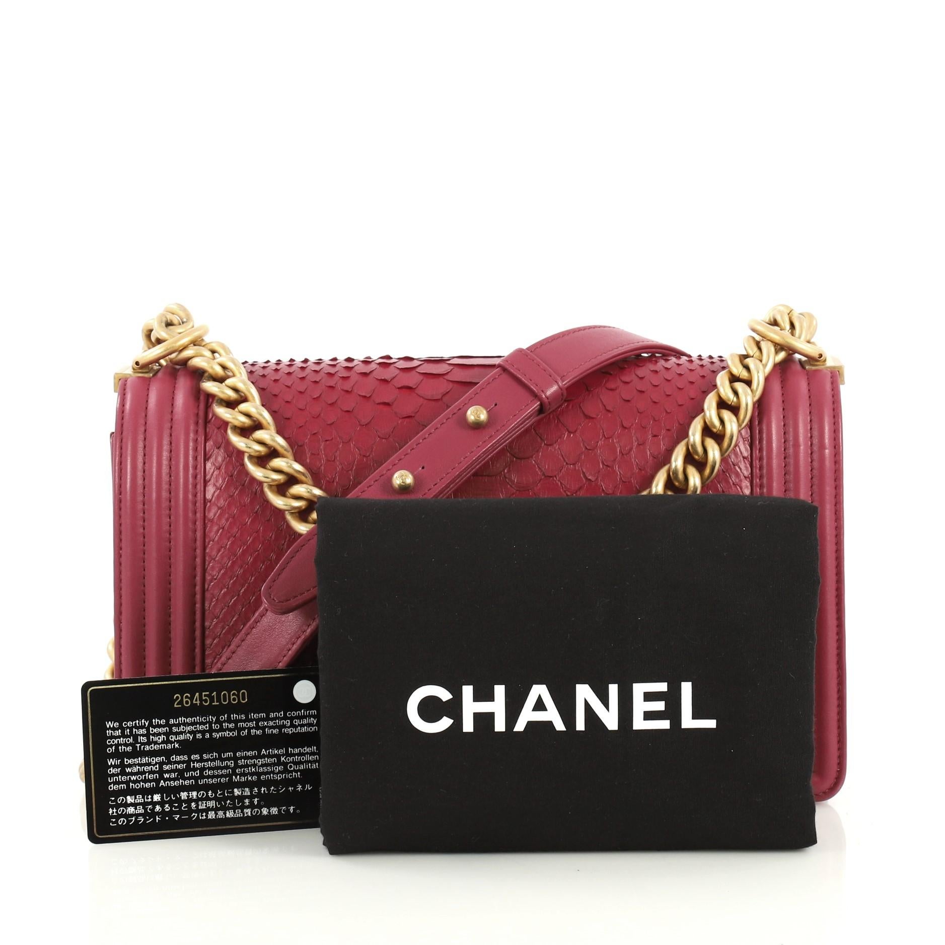 This Chanel Boy Flap Bag Python Old Medium, crafted in genuine purple python and leather, features a chain link strap with a leather pad and aged gold-tone hardware. Its Boy push-lock closure opens to a purple leather interior with slip pocket.
