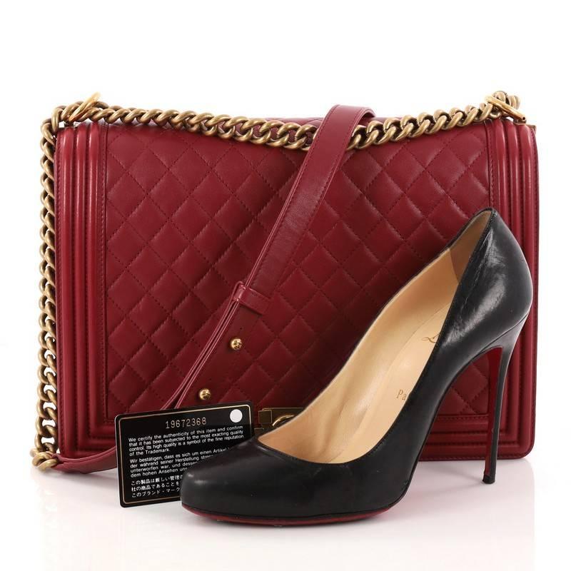 This authentic Chanel Boy Flap Bag Quilted Calfskin Large is every woman's dream. Crafted in luxurious dark red quilted calfskin leather, this popular enviable Boy bag features chain-link strap with leather pads, iconic CC logo with unique-push lock