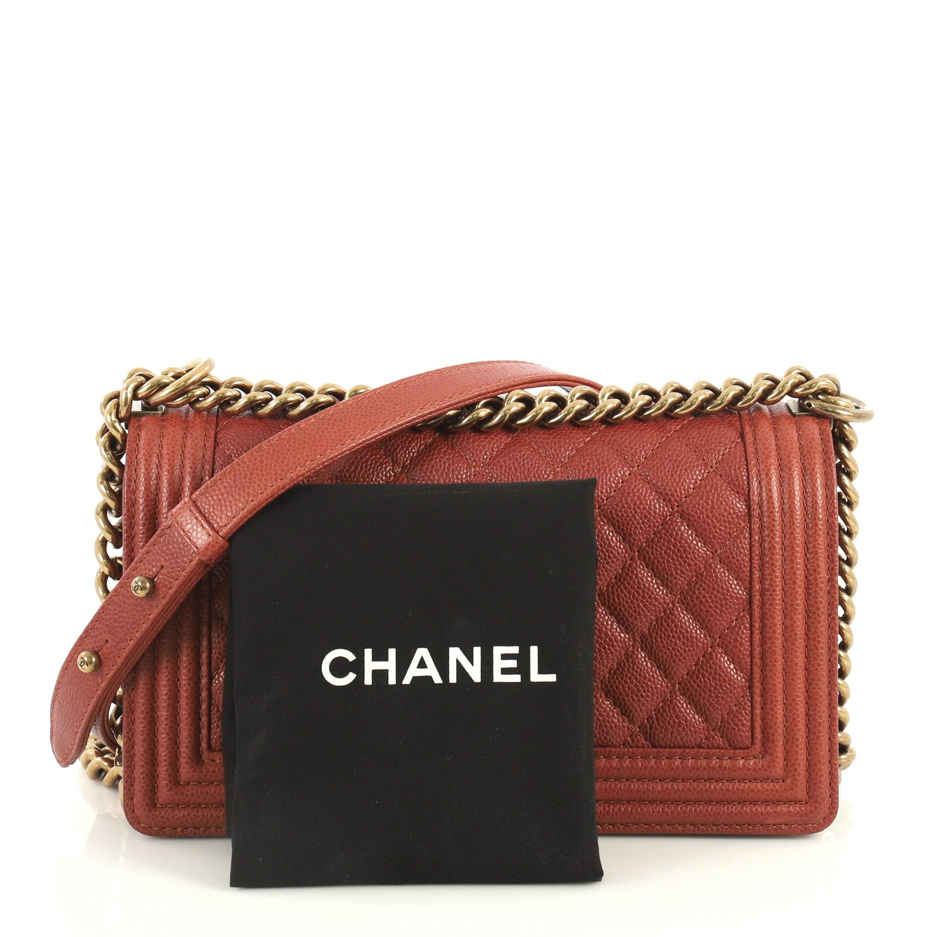 This Chanel Boy Flap Bag Quilted Caviar Old Medium, crafted from red quilted caviar leather, features chain link strap with leather shoulder pad and aged gold-tone hardware. Its CC Boy logo push-lock closure opens to a red fabric interior with slip