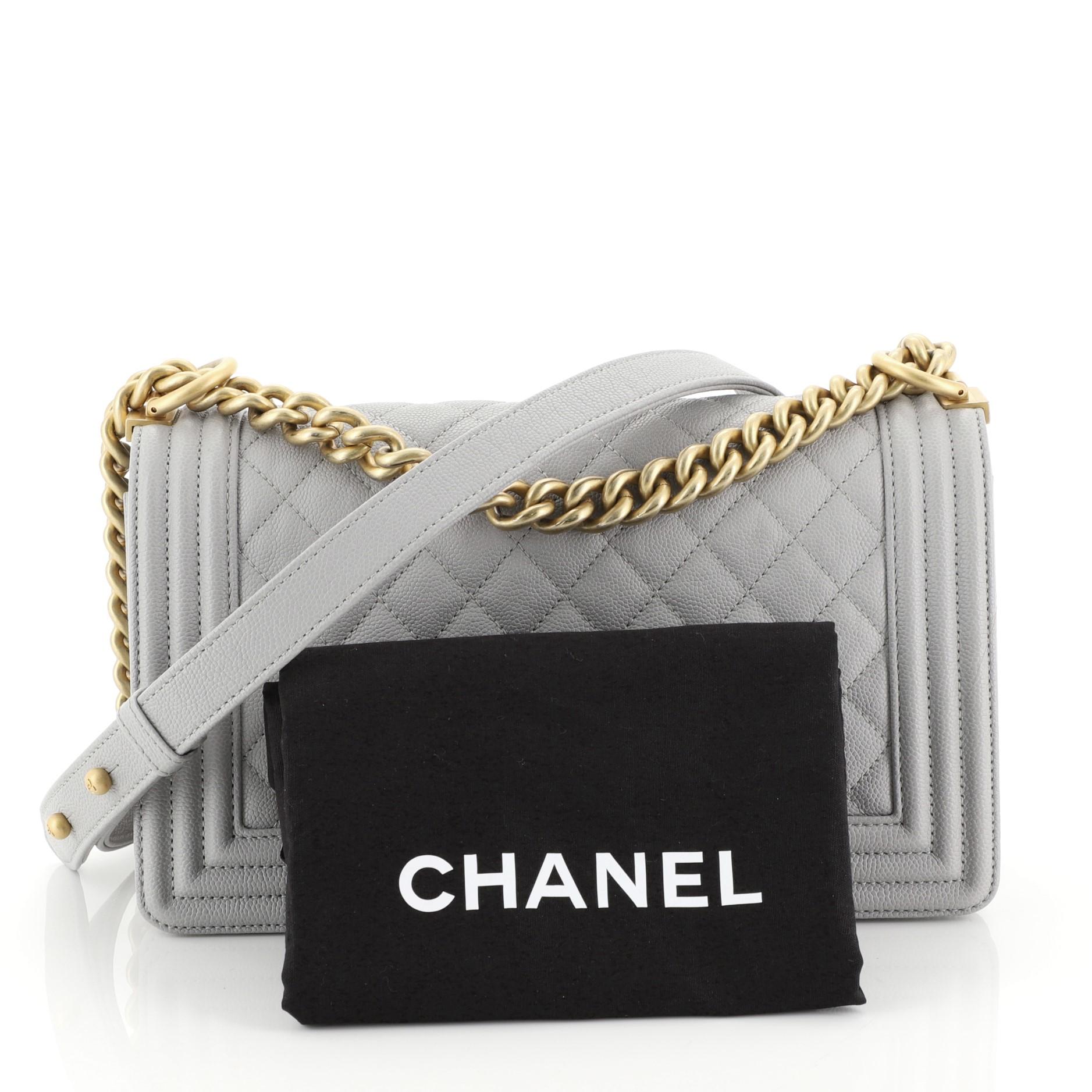 This Chanel Boy Flap Bag Quilted Caviar Old Medium, crafted from gray quilted caviar leather, features chain link strap with leather shoulder pad and gold-tone hardware. Its CC boy logo push-lock closure opens to a gray fabric interior with slip