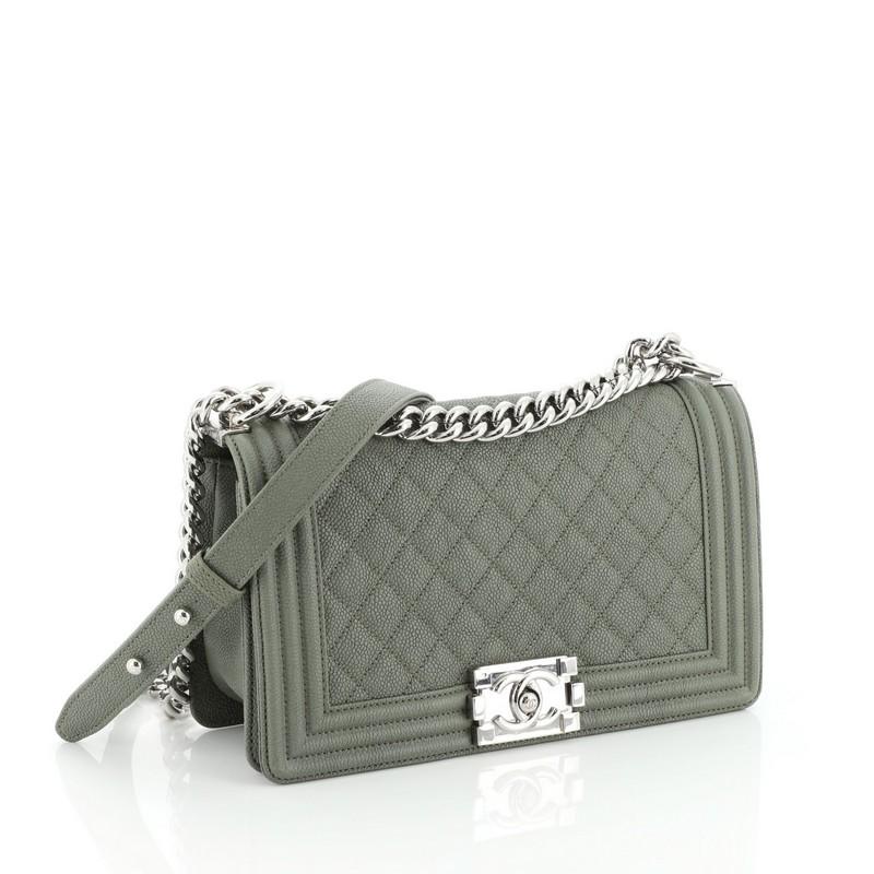 This Chanel Boy Flap Bag Quilted Caviar Old Medium, crafted from green quilted caviar leather, features chain link strap with leather shoulder pad and silver-tone hardware. Its CC boy logo push-lock closure opens to a green fabric interior with slip