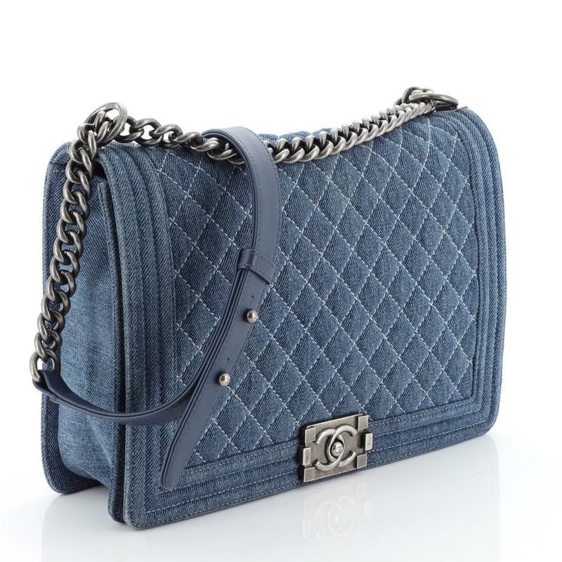 This Chanel Boy Flap Bag Quilted Denim Large, crafted from blue quilted denim, features chain link strap with leather shoulder pad and aged silver-tone hardware. Its CC Boy logo push-lock closure opens to a blue leather interior with zip pocket.