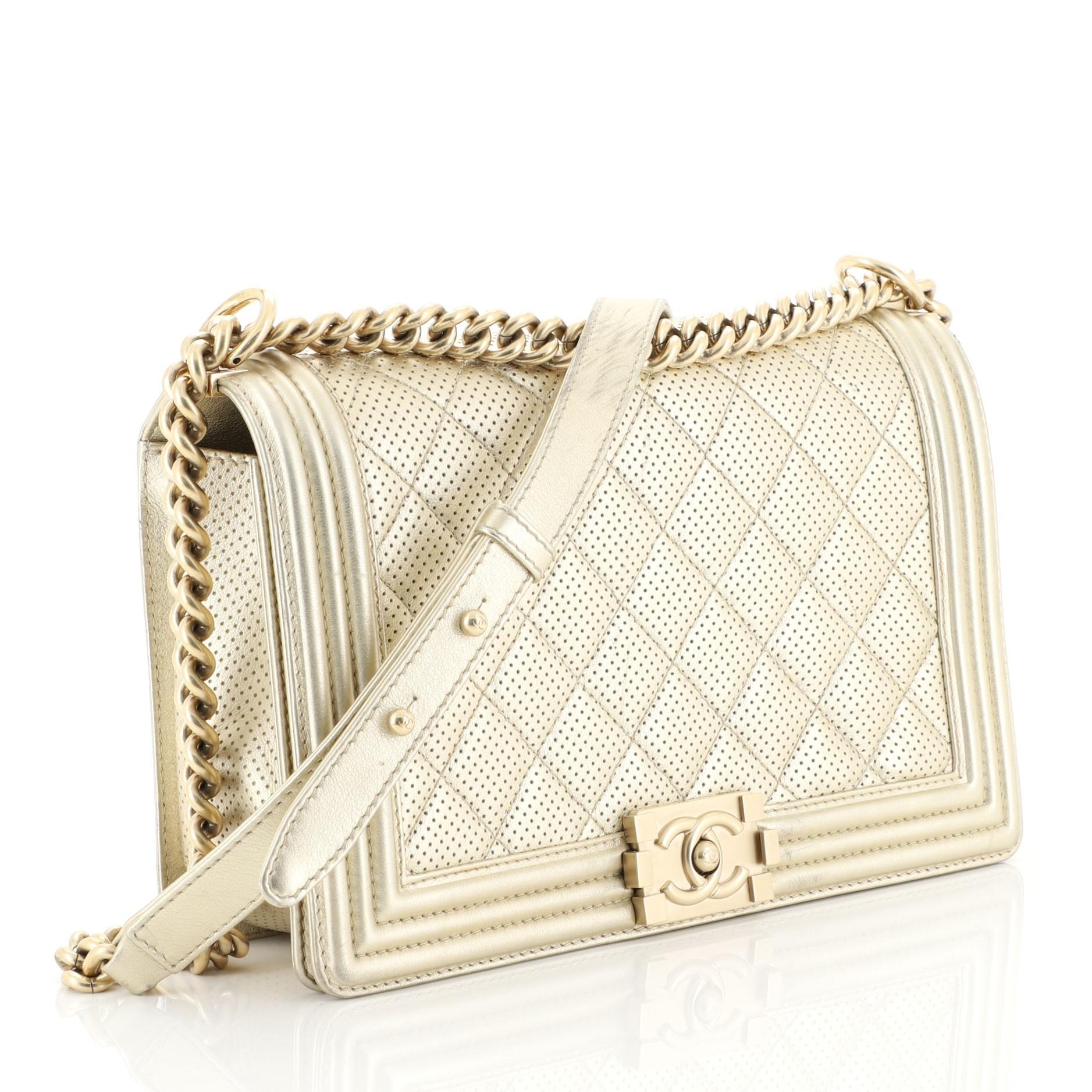 This Chanel Boy Flap Bag Quilted Perforated Lambskin New Medium, crafted from metallic gold perforated quilted lambskin leather, features chain link strap with leather shoulder pad and matte gold-tone hardware. Its CC boy push-lock closure opens to