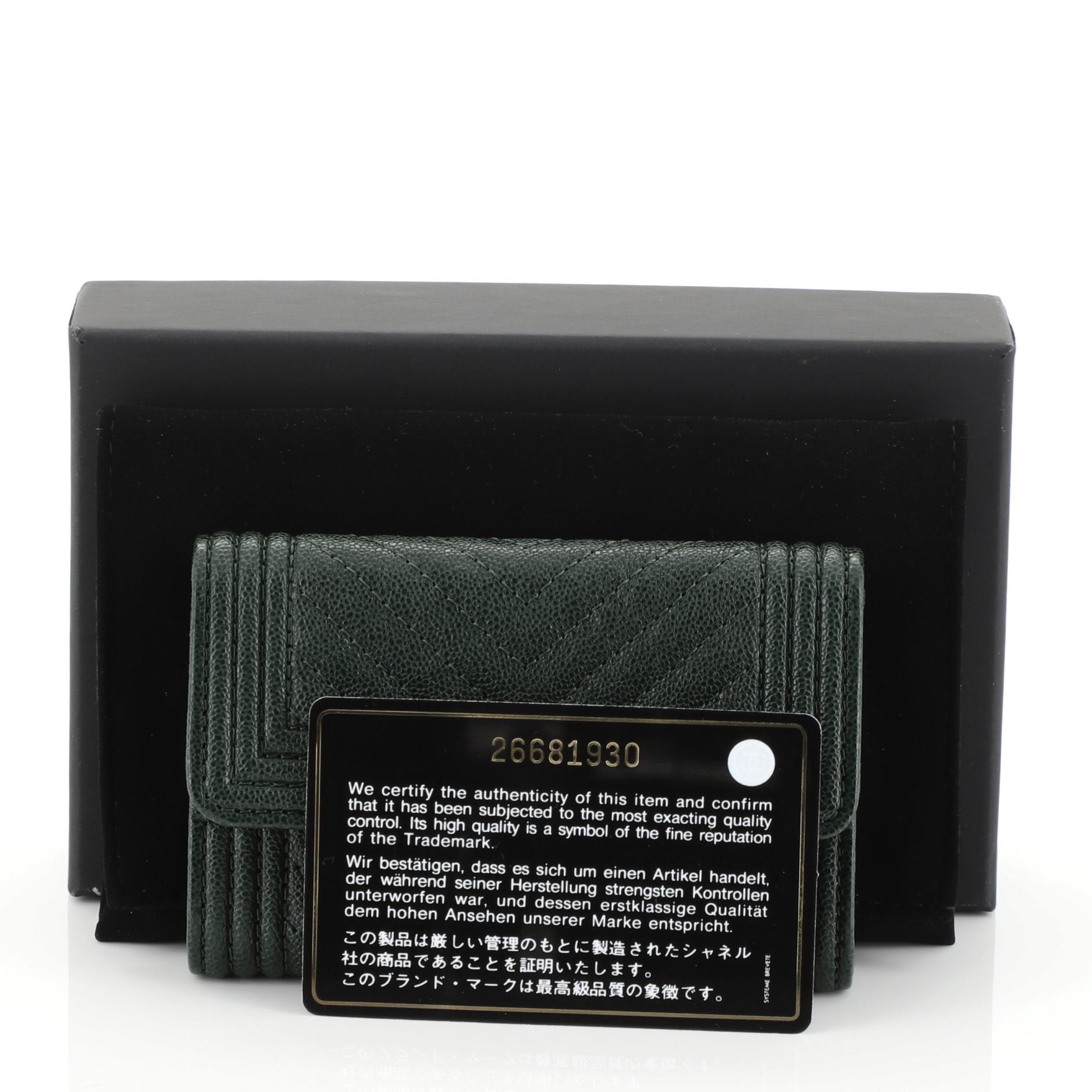 This Chanel Boy Flap Card Holder Chevron Caviar, crafted from green chevron caviar leather, features decorative CC boy push lock and gold-tone hardware. Its snap button closure opens to a green fabric interior. Hologram sticker reads: 26681930.