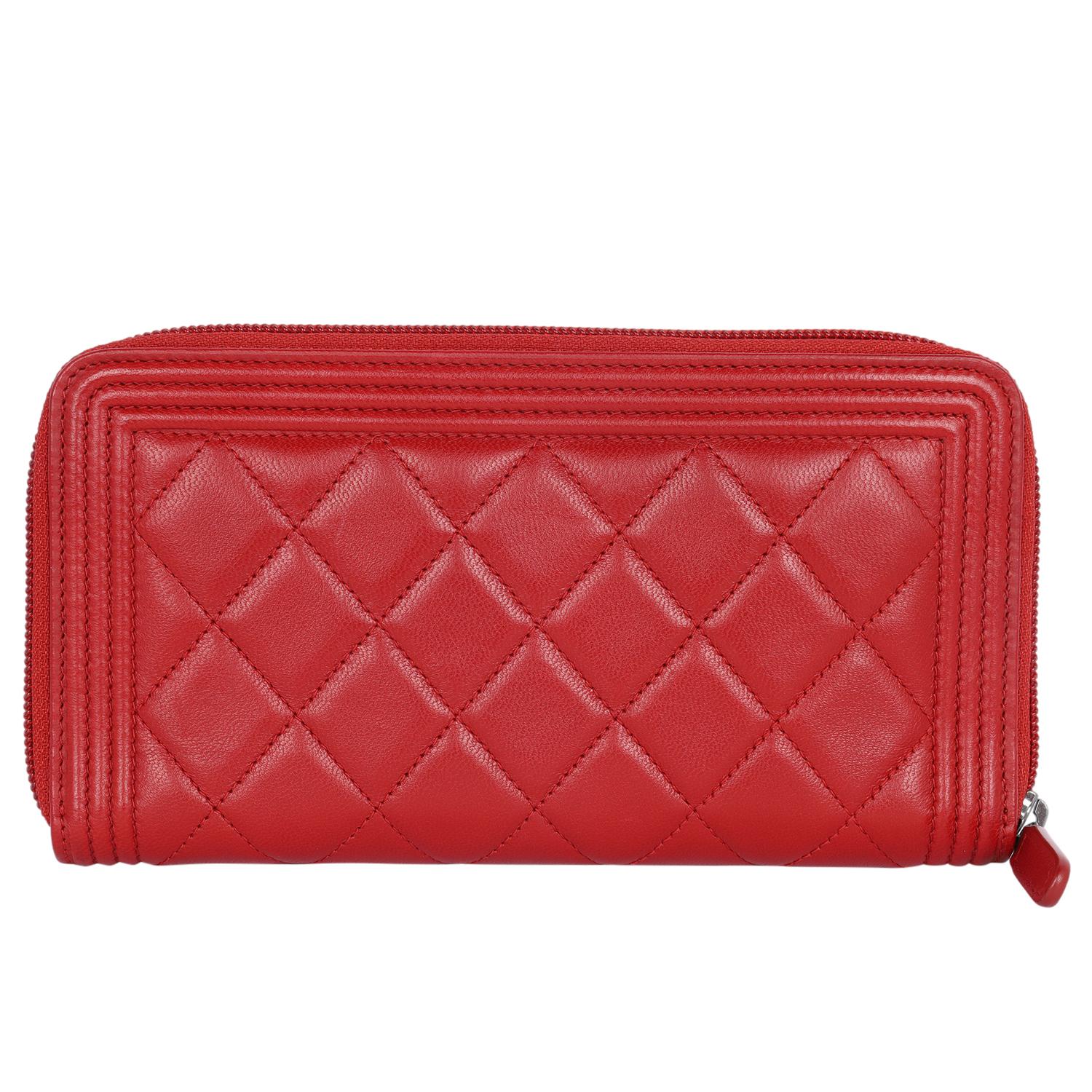 Authentic, pre-owned Chanel boy lambskin diamond quilted wallet in red. Features diamond quilted luxurious red leather with a Chanel CC logo in silver, zip around closure, red pull tab, large interior with  8 cc slots, billfold panel slots, long