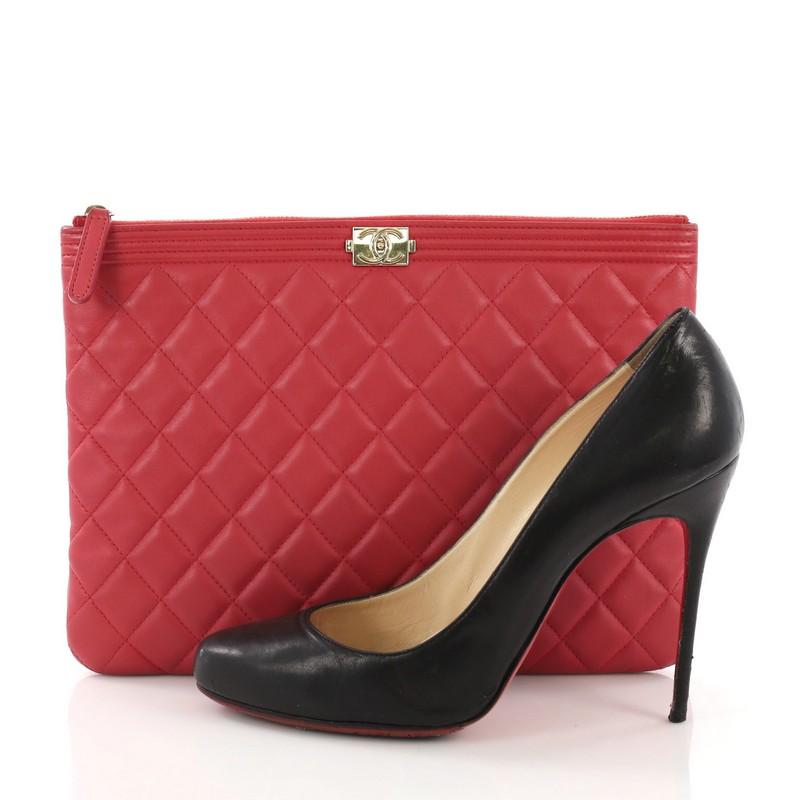 This Chanel Boy O Case Clutch Quilted Lambskin Medium, crafted from red quilted lambskin, features linear quilted top border, Chanel boy logo press lock, and gold-tone hardware. Its zip closure opens to a red nylon interior. Hologram sticker reads: