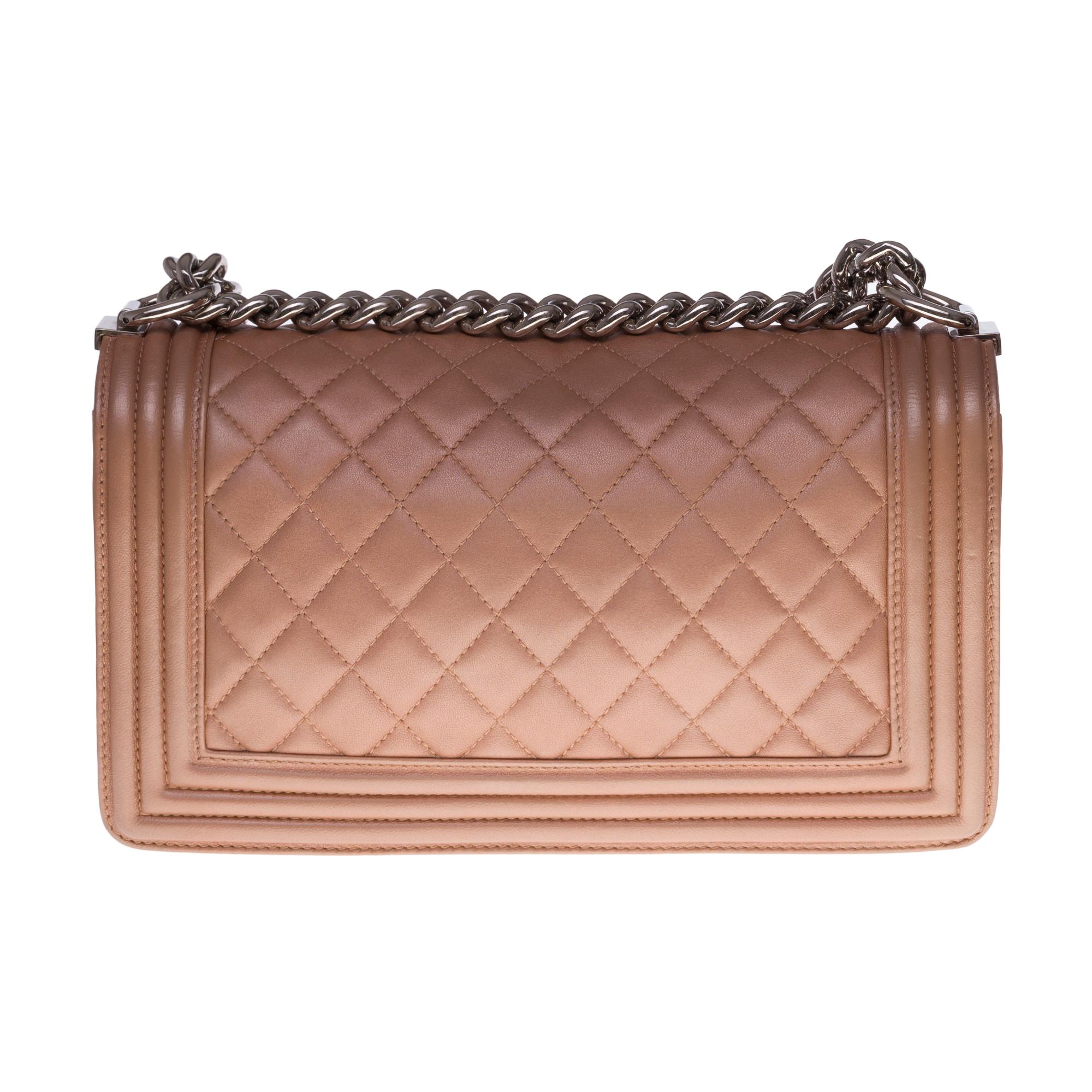 The iconic Chanel Boy Old Medium shoulder bag in bronze quilted leather, silver-plated metal trim, an adjustable silver-plated metal chain handle allowing a shoulder or shoulder strap.

A silver metal logo closure on the flap.
Lining in khaki