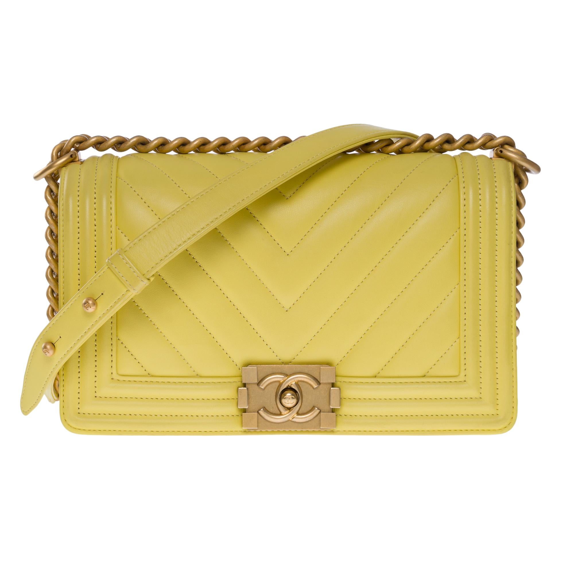 Exquisite Chanel Boy Old Medium shoulder bag in lemon yellow herringbone quilted leather, matte gold metal hardware, matte gold metal chain handle and yellow leather for a shoulder and crossbody carry
Full flap closure, push button clasp with CC