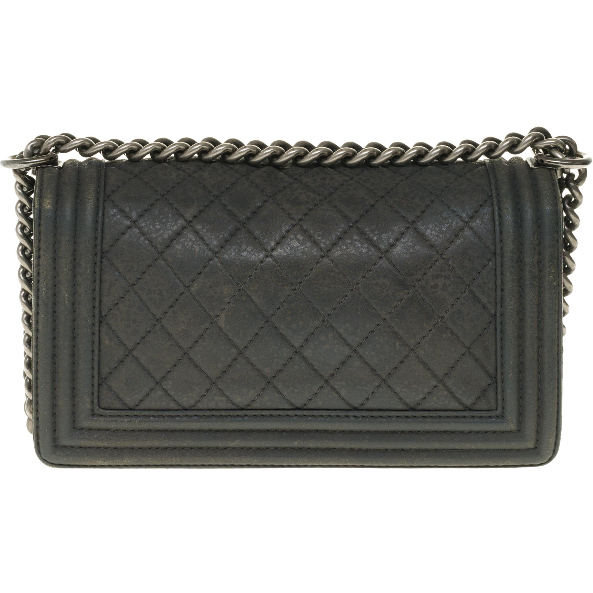 The iconic shoulder bag Chanel Boy quilted leather effect aged gray, trimmed in aged silver metal (gun barrel), an adjustable chain handle in silver metal allowing a shoulder or shoulder strap.

An antique silver metal logo closure on the