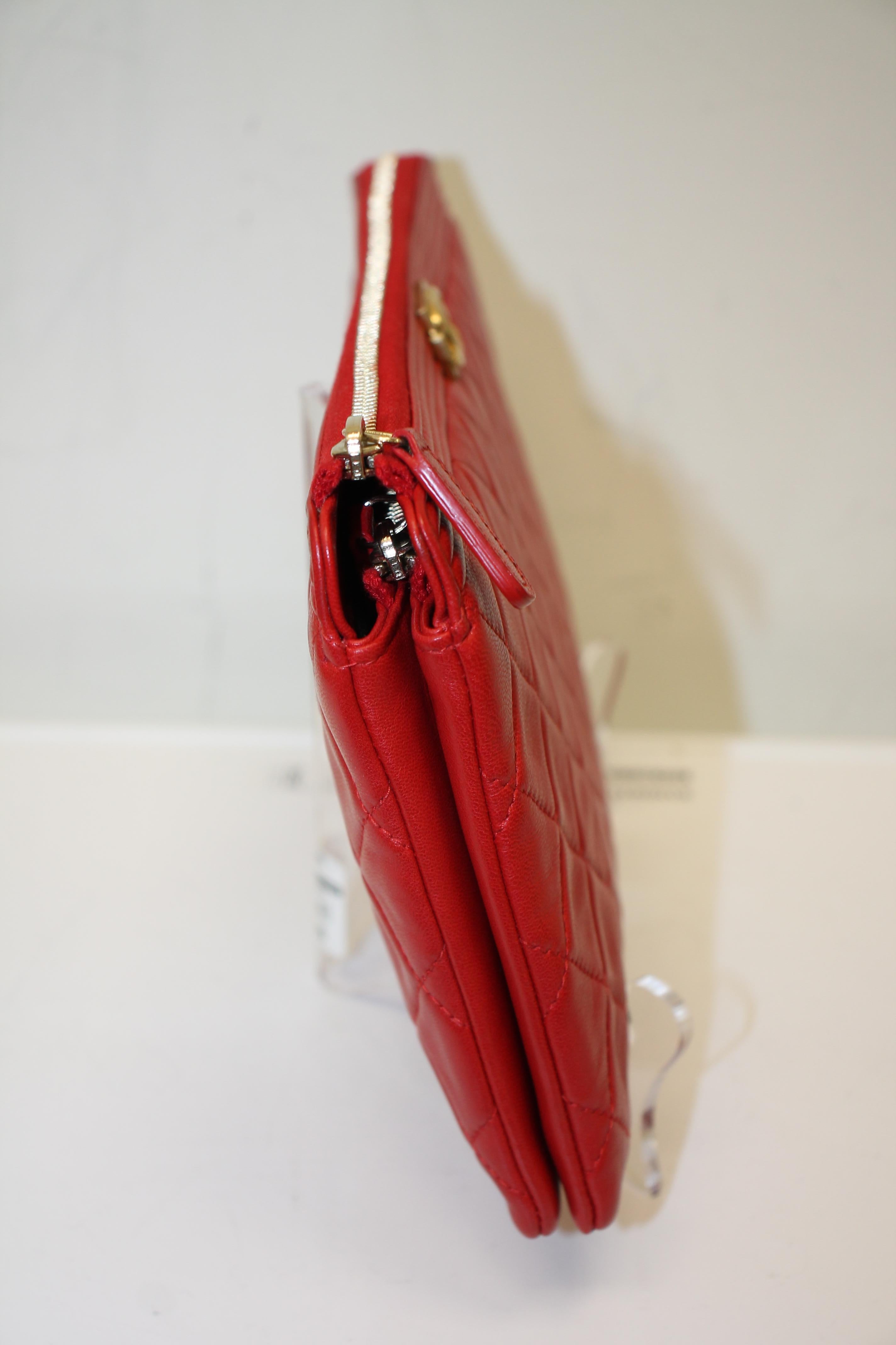 Red calfskin. Brass hardware. Top zipper closure. Features 