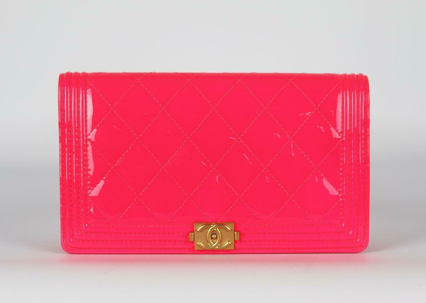 Made in Italy, this Chanel wallet has been made from neon-pink patent-leather exterior with bright-pink leather interior, this piece is decorated with Chanel's gold-toned logo on the front and finished with card slots and zip pouch for your