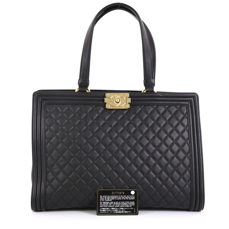 This Chanel Boy Shopping Tote Quilted Lambskin Large, crafted from black quilted lambskin leather, features dual flat leather top handles, smooth leather trims, protective base studs and aged gold-tone hardware. Its Boy push-lock closure opens to a