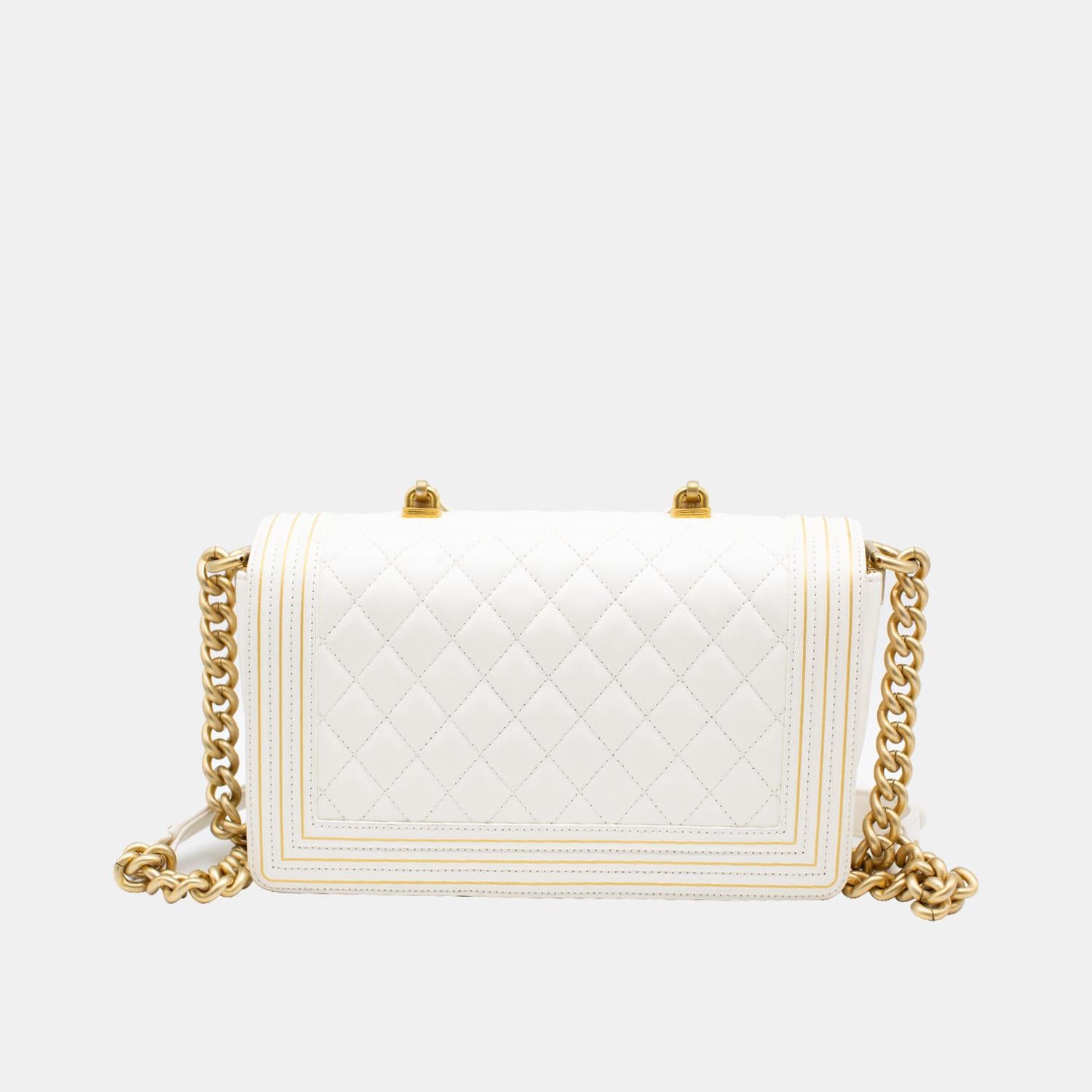 The Chanel Boy Studded Handle Bag from the Pre-Fall 2017 collection is a sophisticated yet eye-catching version of the iconic Boy bags. Crafted from snow-white lambskin with diamond quilting, it features a signature gold-toned push-lock closure, a